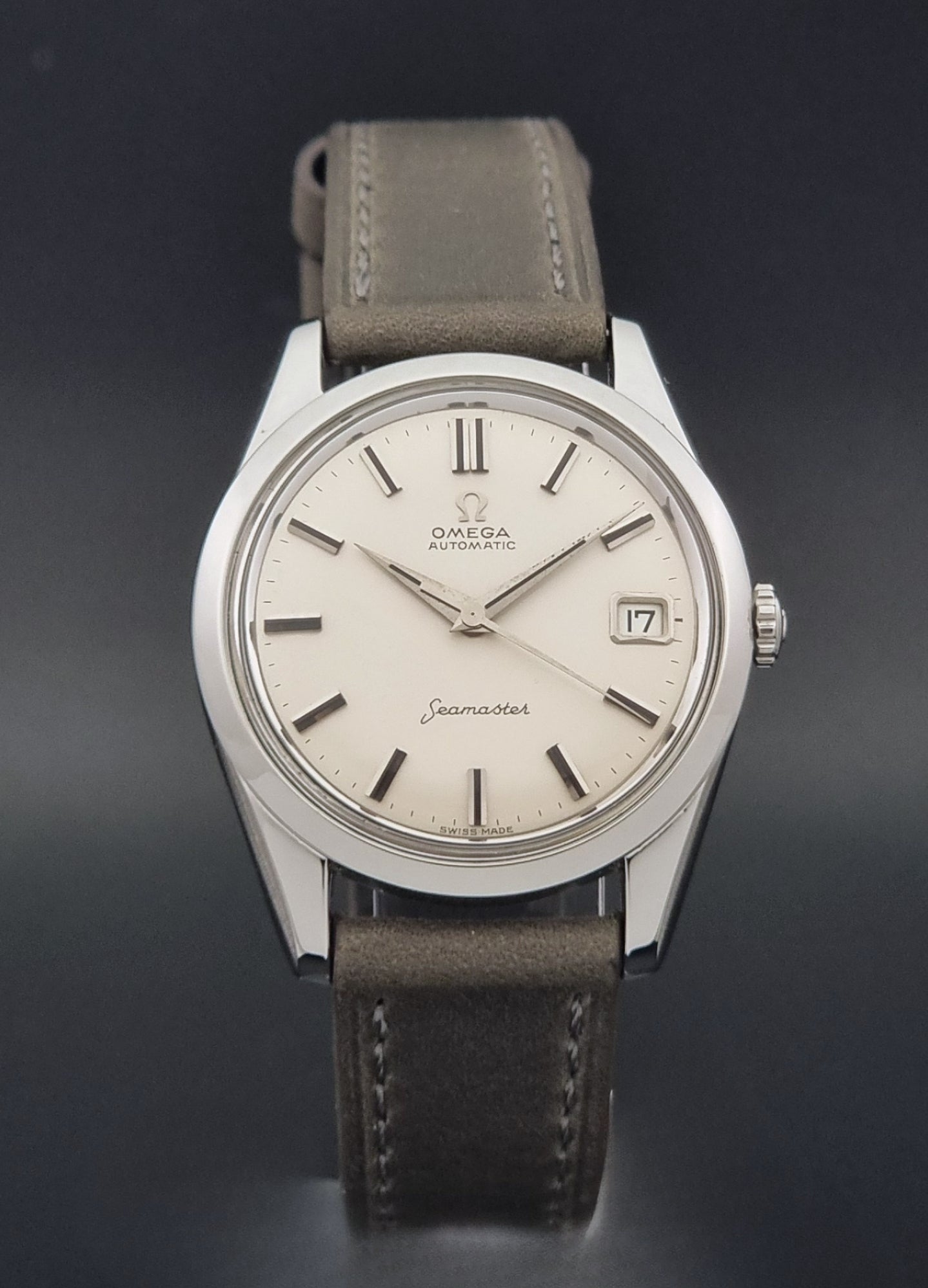 Vintage Omega Seamaster 14763 with a grey leather strap on a dark background close dial view