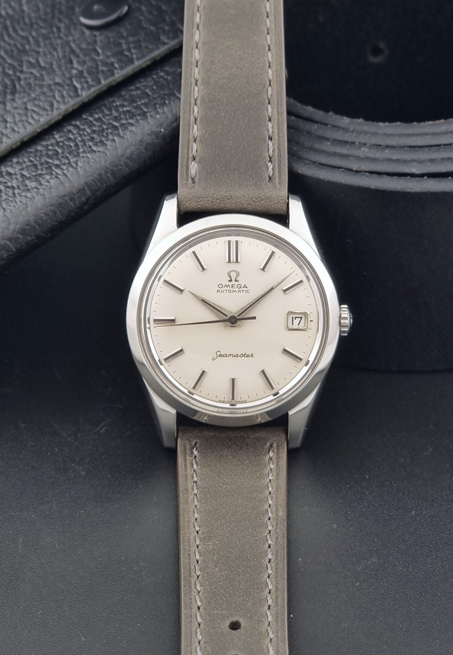 Vintage Omega Seamaster 14763 with a grey leather strap on a dark background dial view