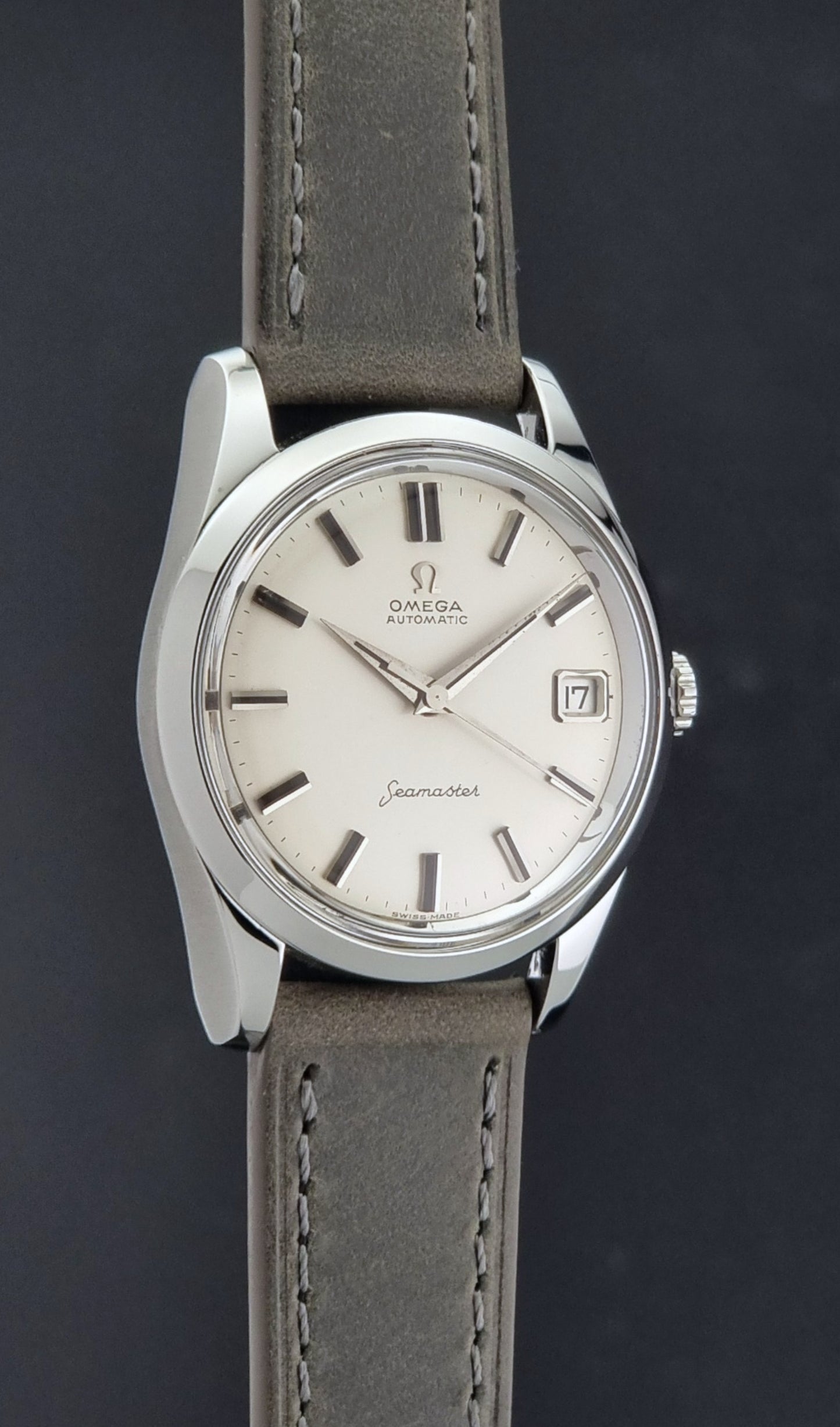 Vintage Omega Seamaster 14763 with a grey leather strap on a dark background side profile view