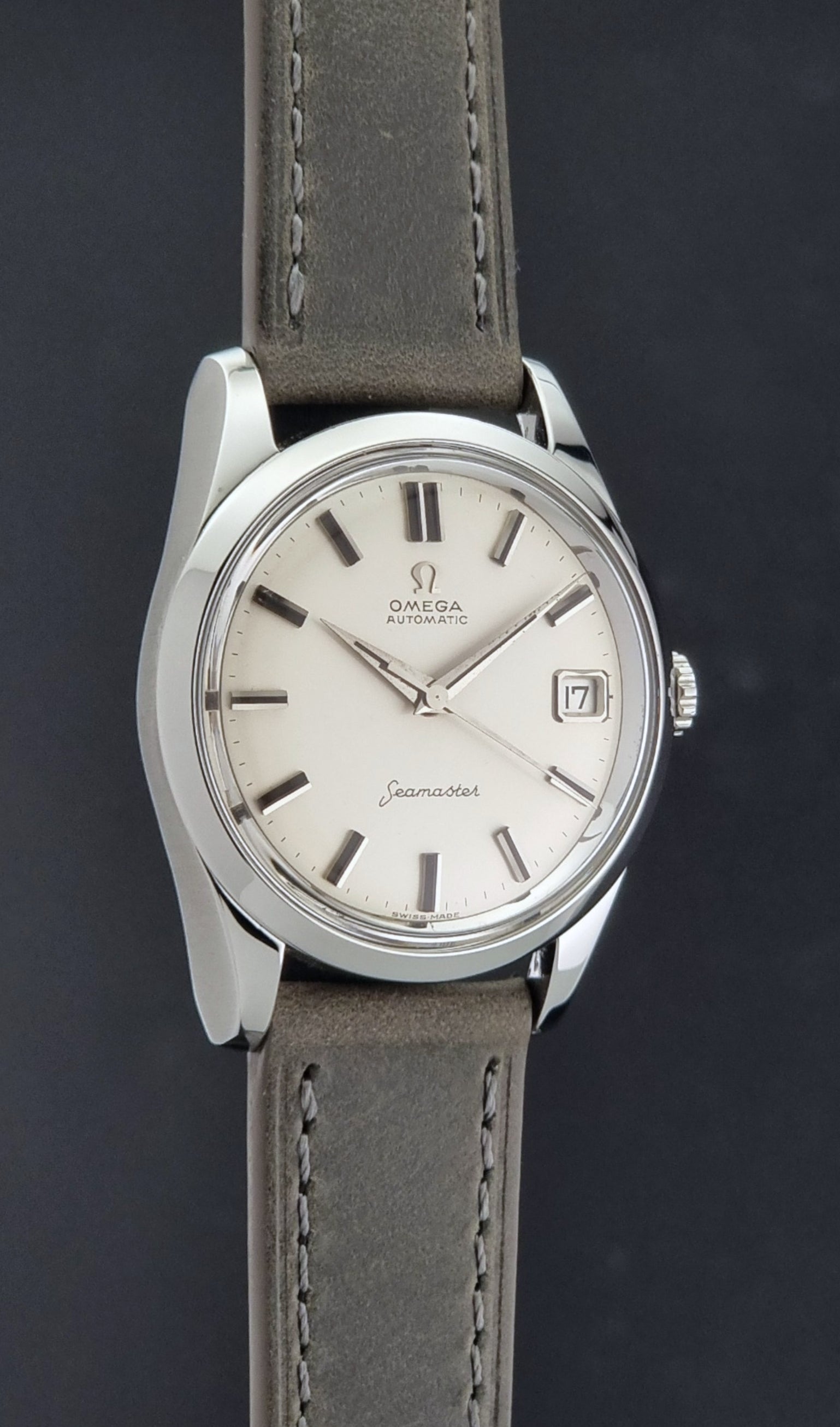 Vintage Omega Seamaster 14763 with a grey leather strap on a dark background side profile view