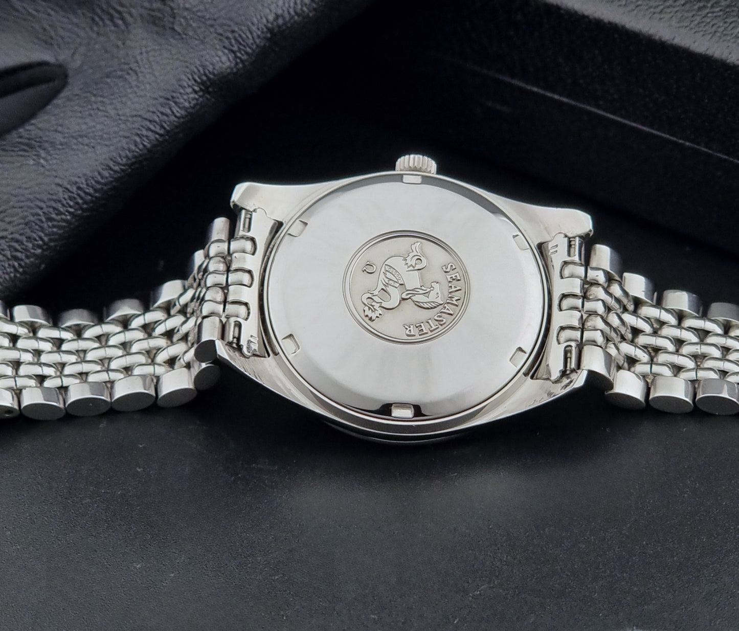 Vintage Omega Wristwatch Seamaster 166.010 watch on a dark gray background case back view