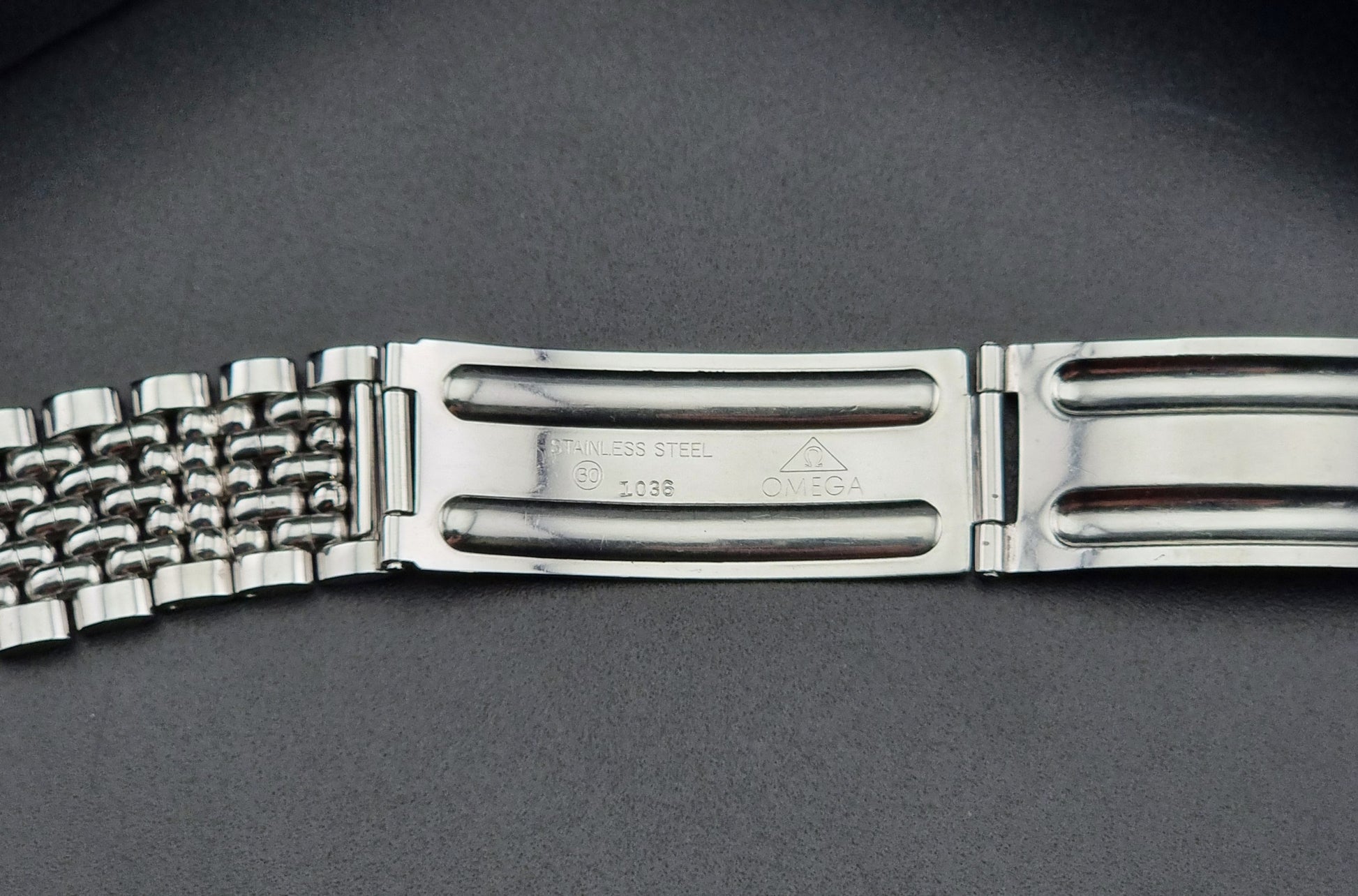 Vintage Omega Wristwatch Seamaster 166.010 watch on a dark gray background clasp view