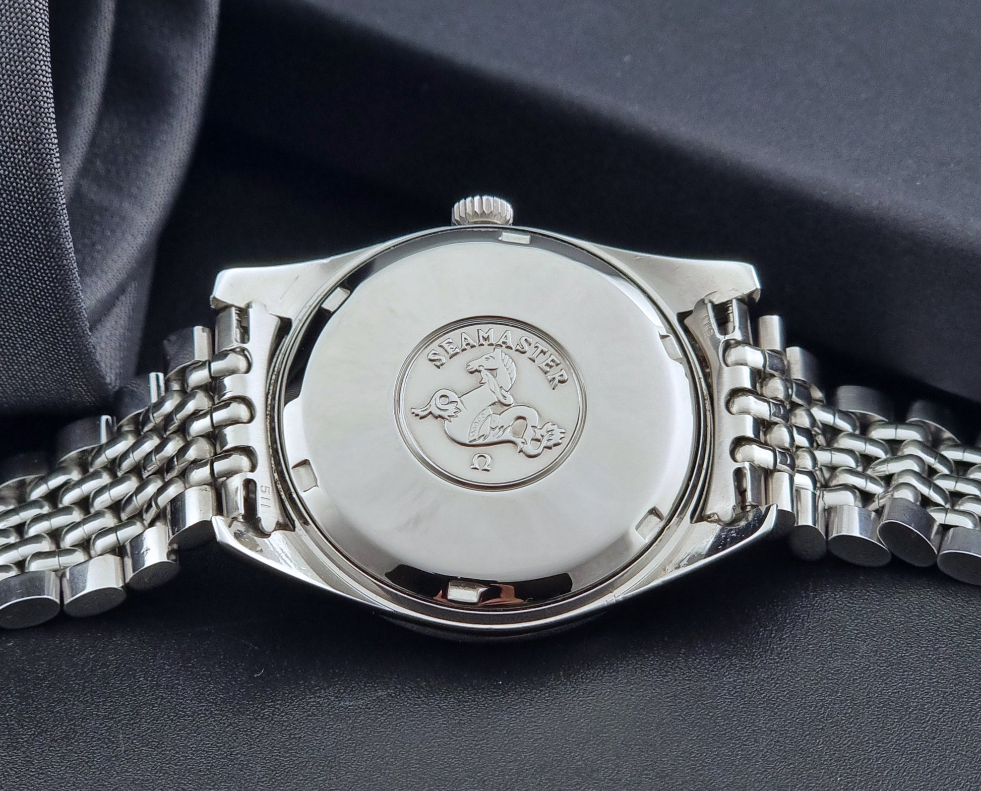 Vintage Omega Wristwatch Seamaster 166.010 Chronometer with stainless steel bracelet on a dark background case back view