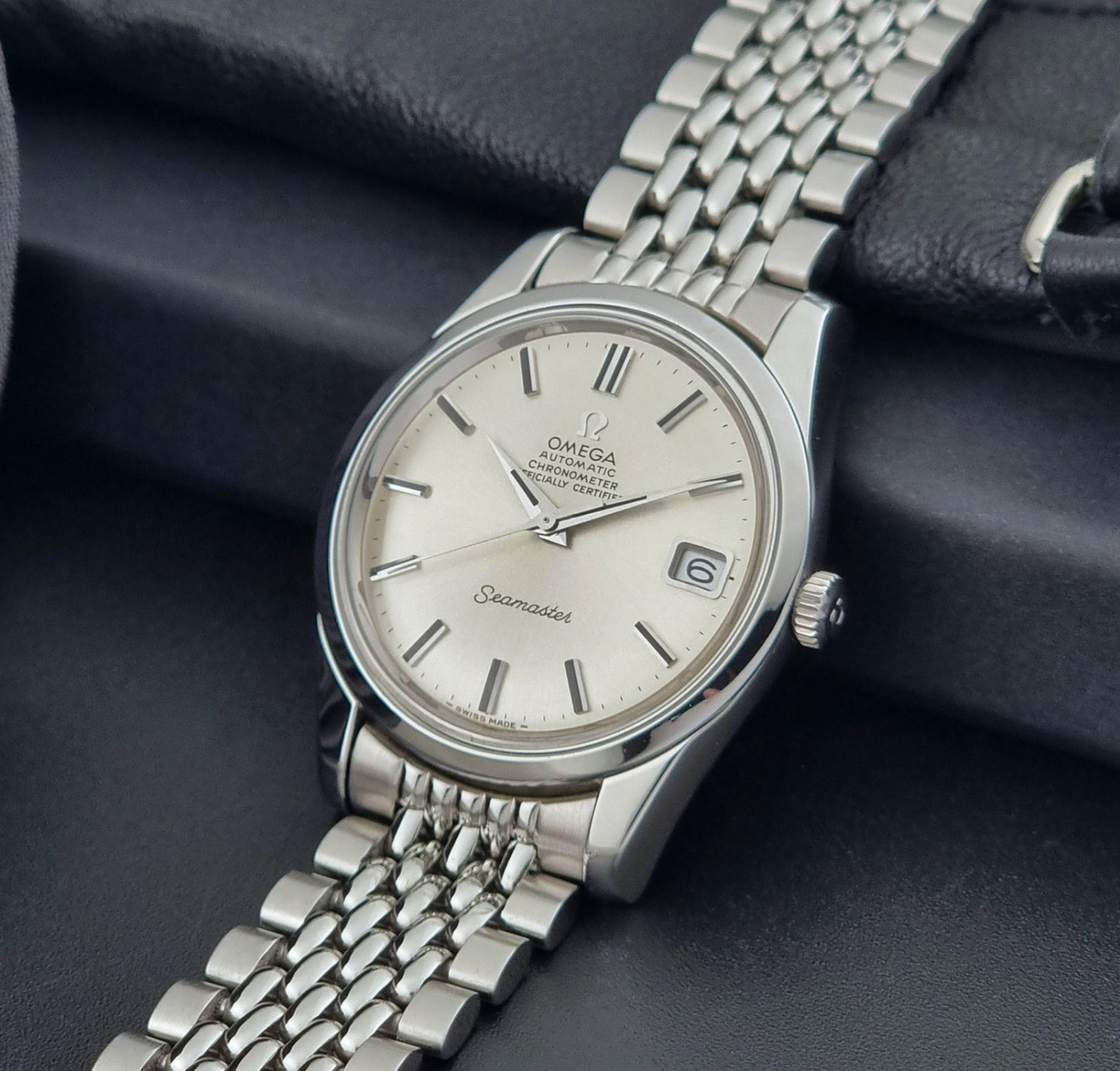 Vintage Omega Wristwatch Seamaster 166.010 Chronometer with stainless steel bracelet on a dark background crown view