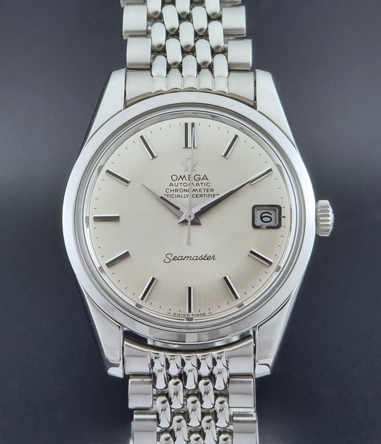Vintage Omega Wristwatch Seamaster 166.010 Chronometer with stainless steel bracelet on a dark background close front view