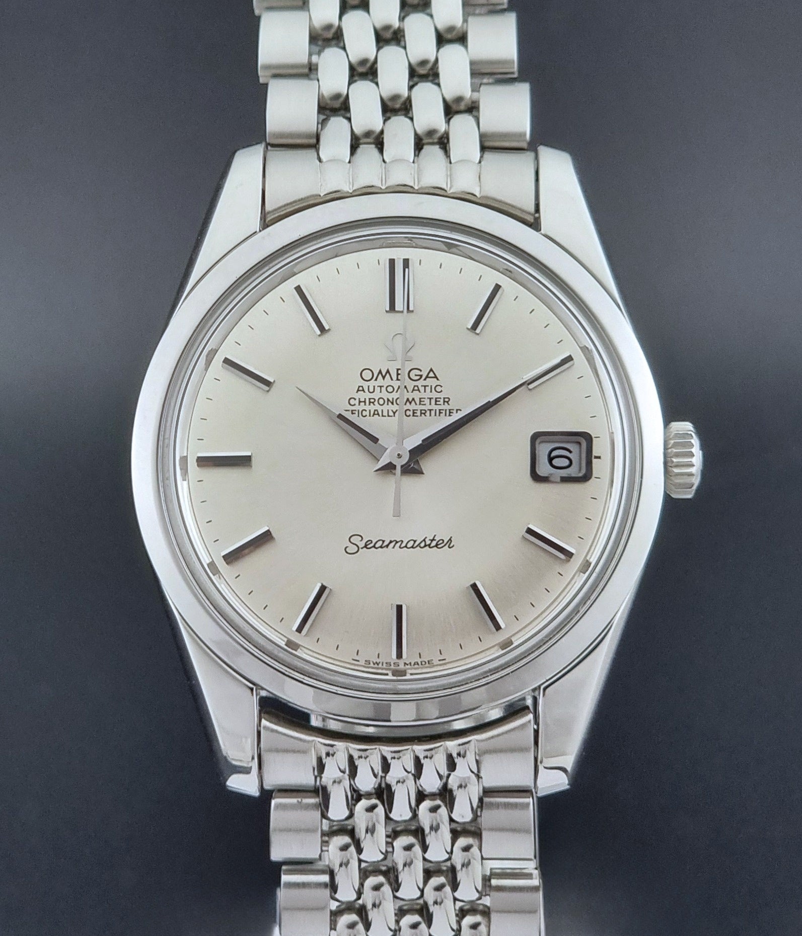 Vintage Omega Wristwatch Seamaster 166.010 Chronometer with stainless steel bracelet on a dark background close front view