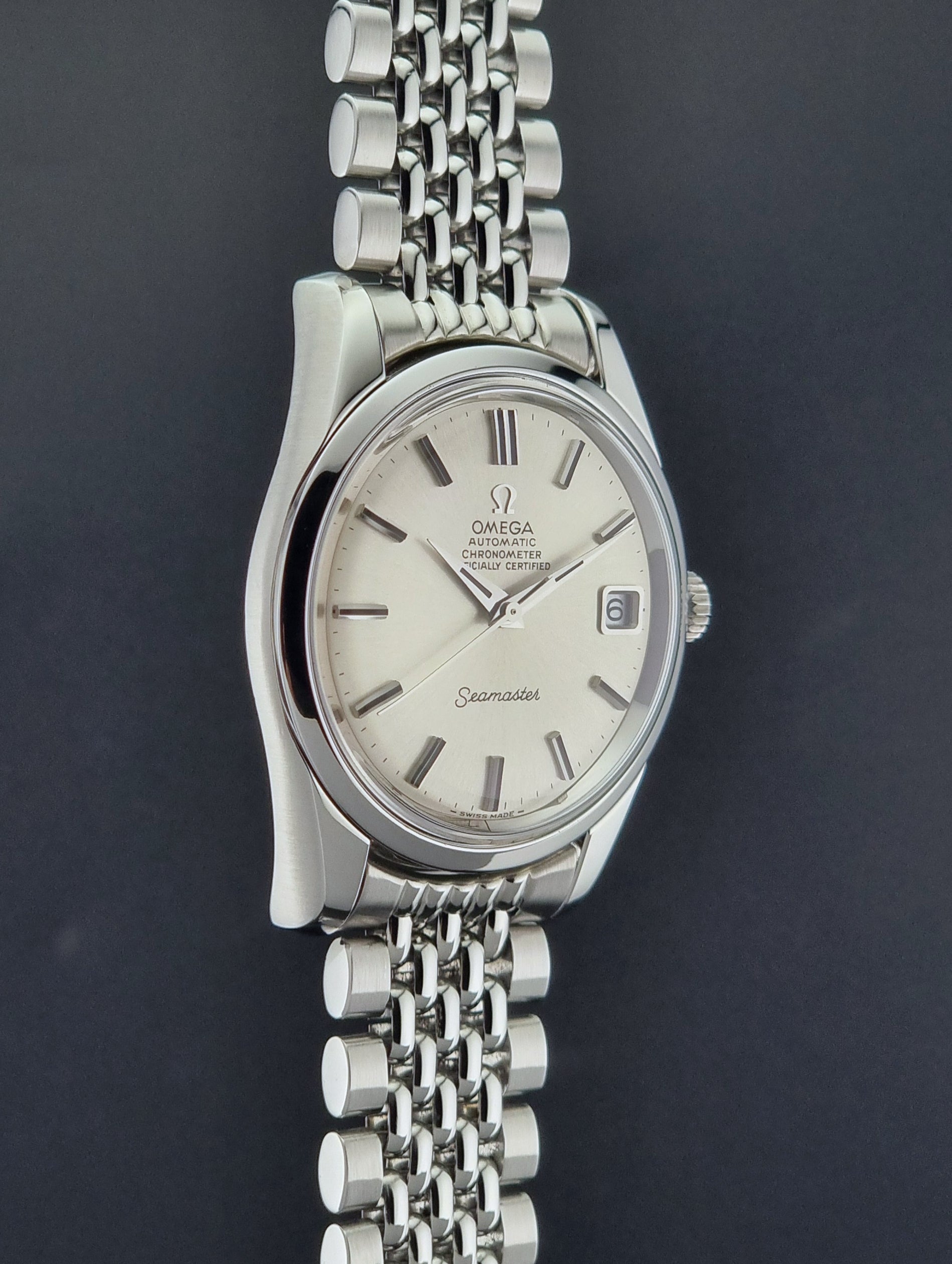 Vintage Omega Wristwatch Seamaster 166.010 Chronometer with stainless steel bracelet on a dark background side profile view