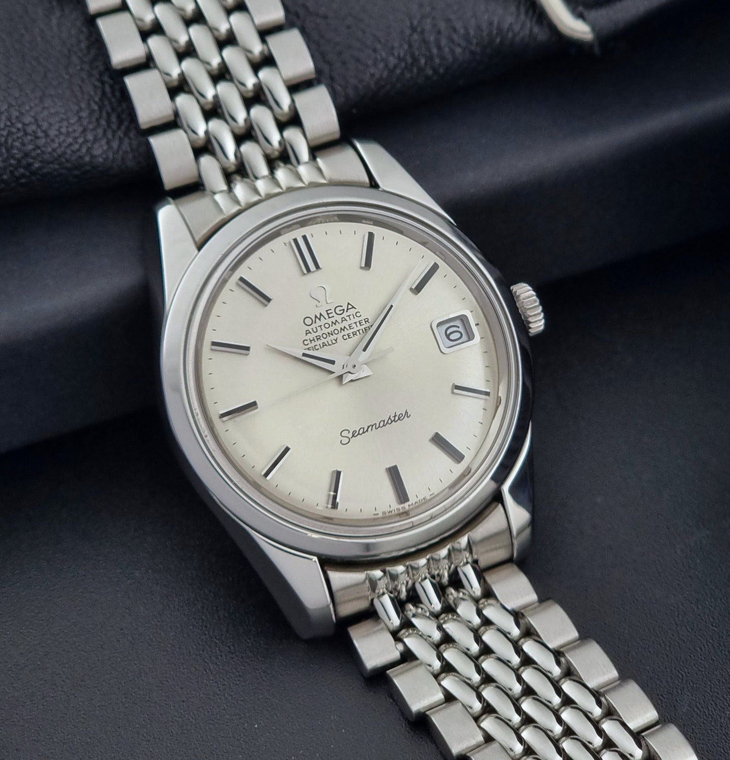 Vintage Omega Wristwatch Seamaster 166.010 Chronometer with stainless steel bracelet on a dark background side view
