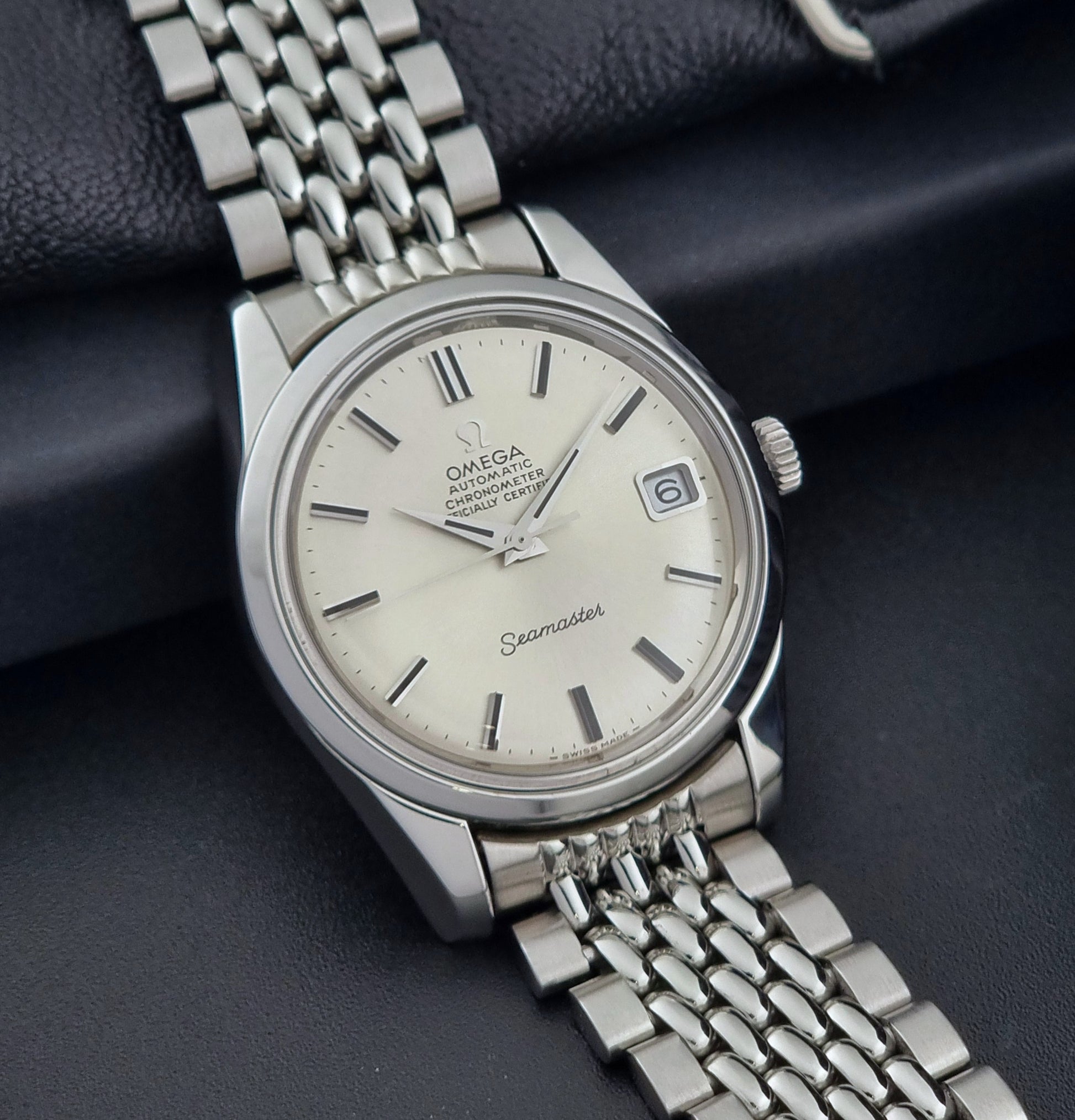 Vintage Omega Wristwatch Seamaster 166.010 Chronometer with stainless steel bracelet on a dark background side view
