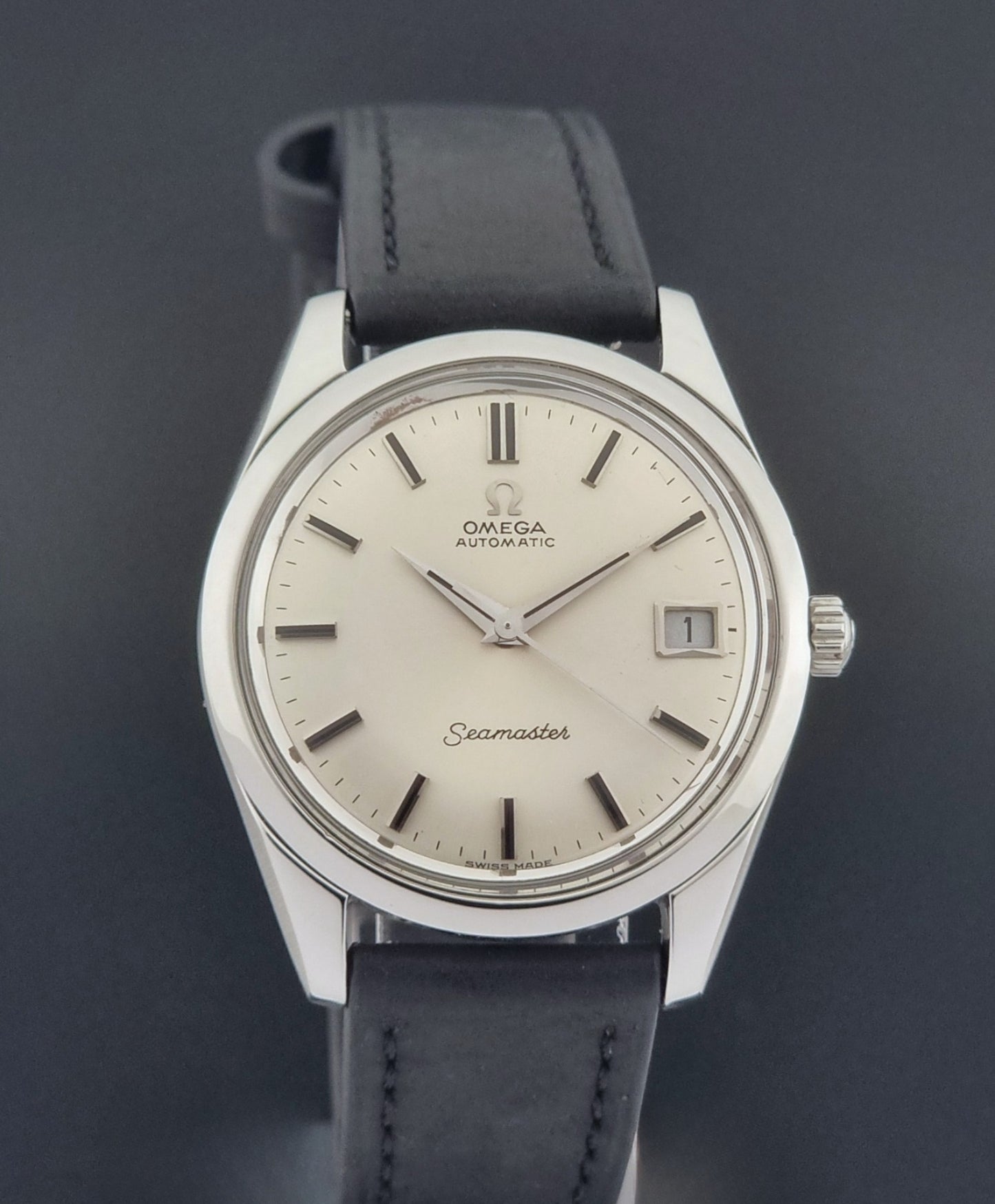 Vintage Omega Wristwatch Seamaster 166.010 with black leather strap on a gray background close dial view