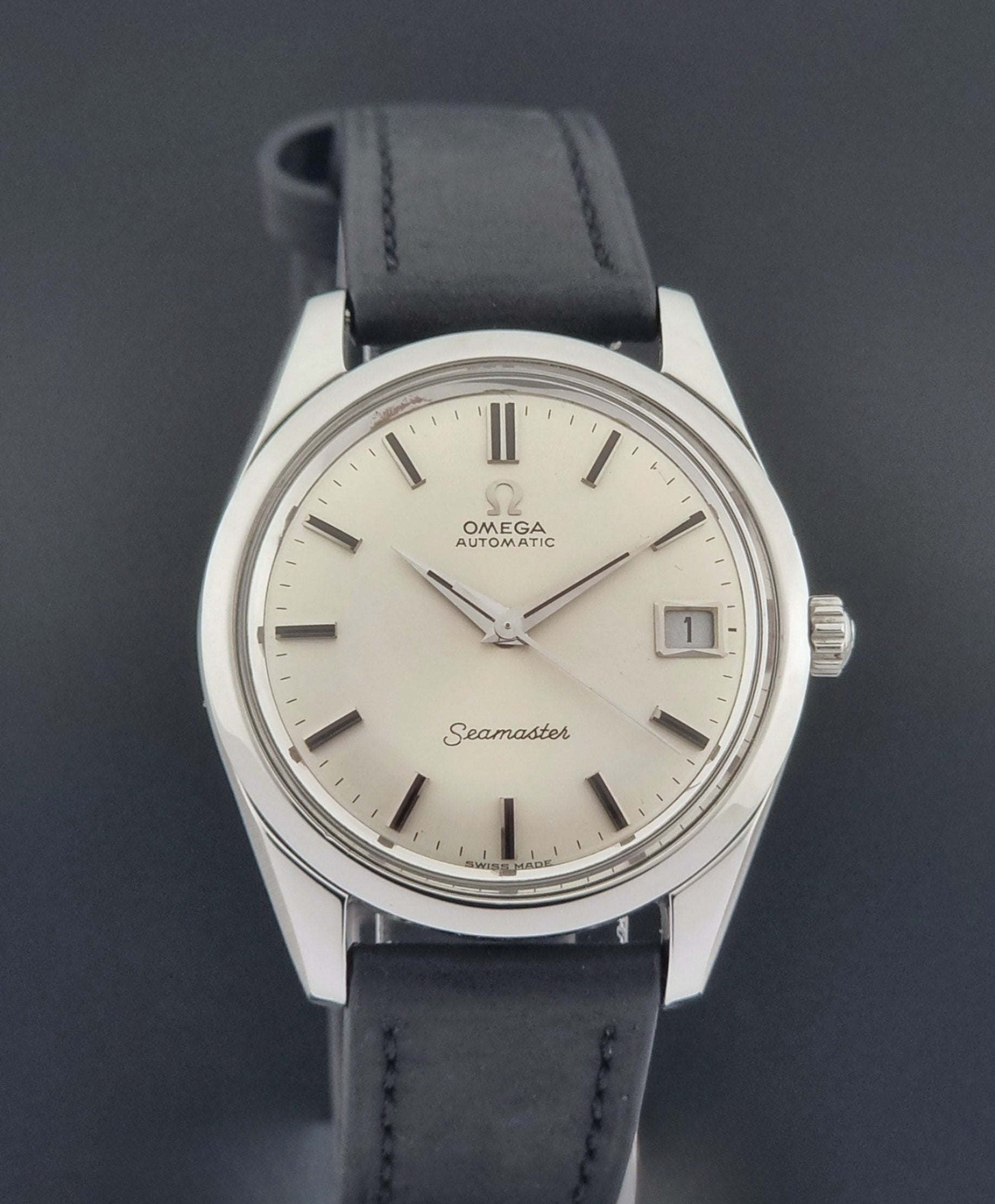 Vintage Omega Wristwatch Seamaster 166.010 with black leather strap on a gray background close dial view