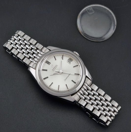 Vintage Omega Wristwatch Seamaster 166.010 with stainless steel bracelet on a dark background dial