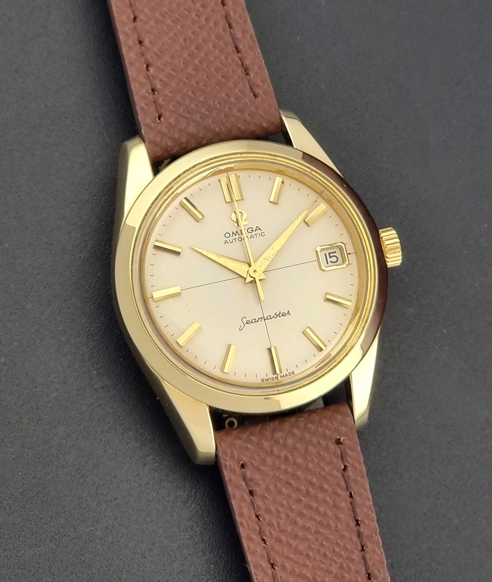 Vintage Omega Wristwatch Seamaster 14763  with a brown leather strap on a dark textured background front view