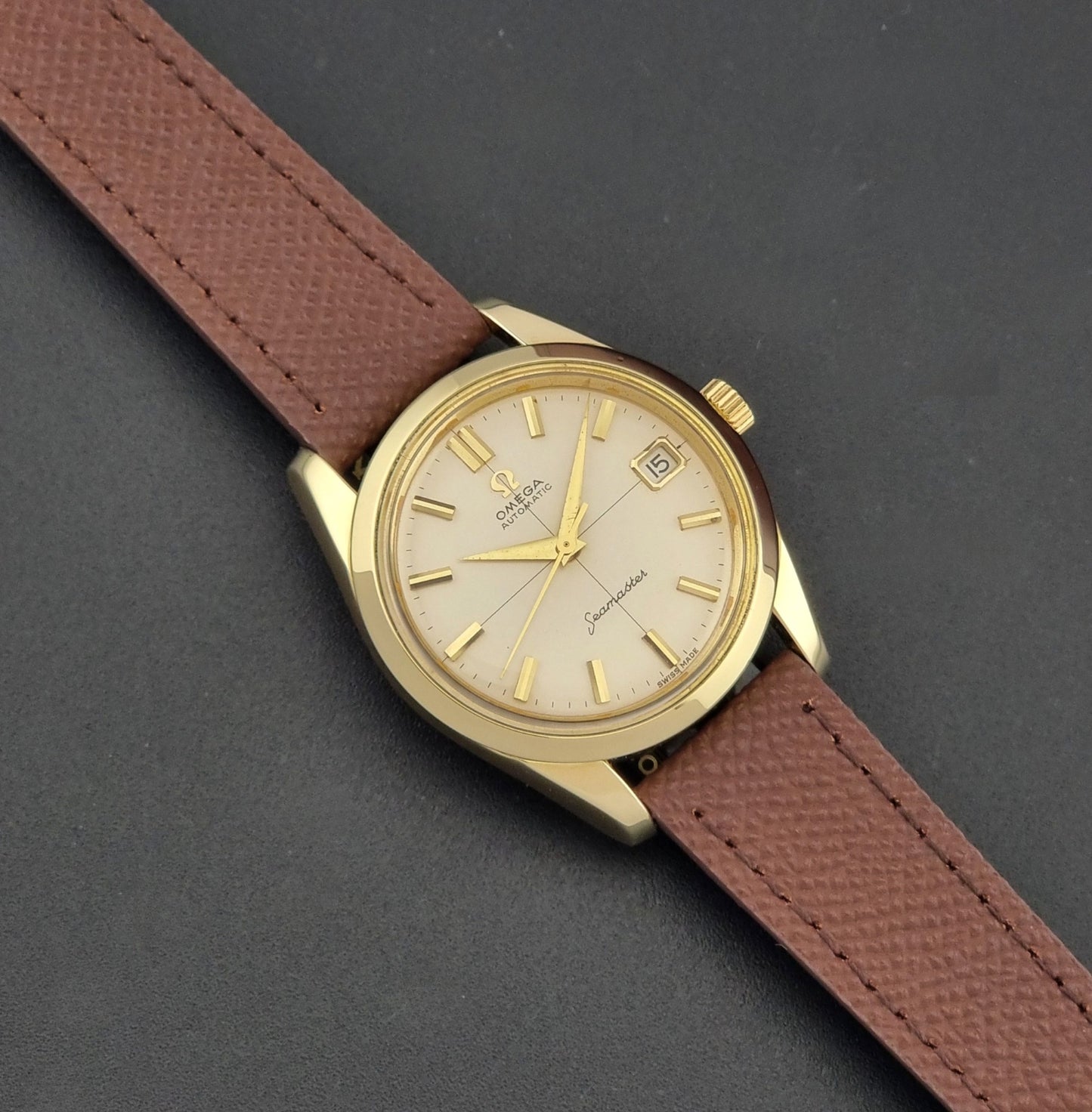 Vintage Omega Wristwatch Seamaster 14763  with a brown leather strap on a dark textured background dial