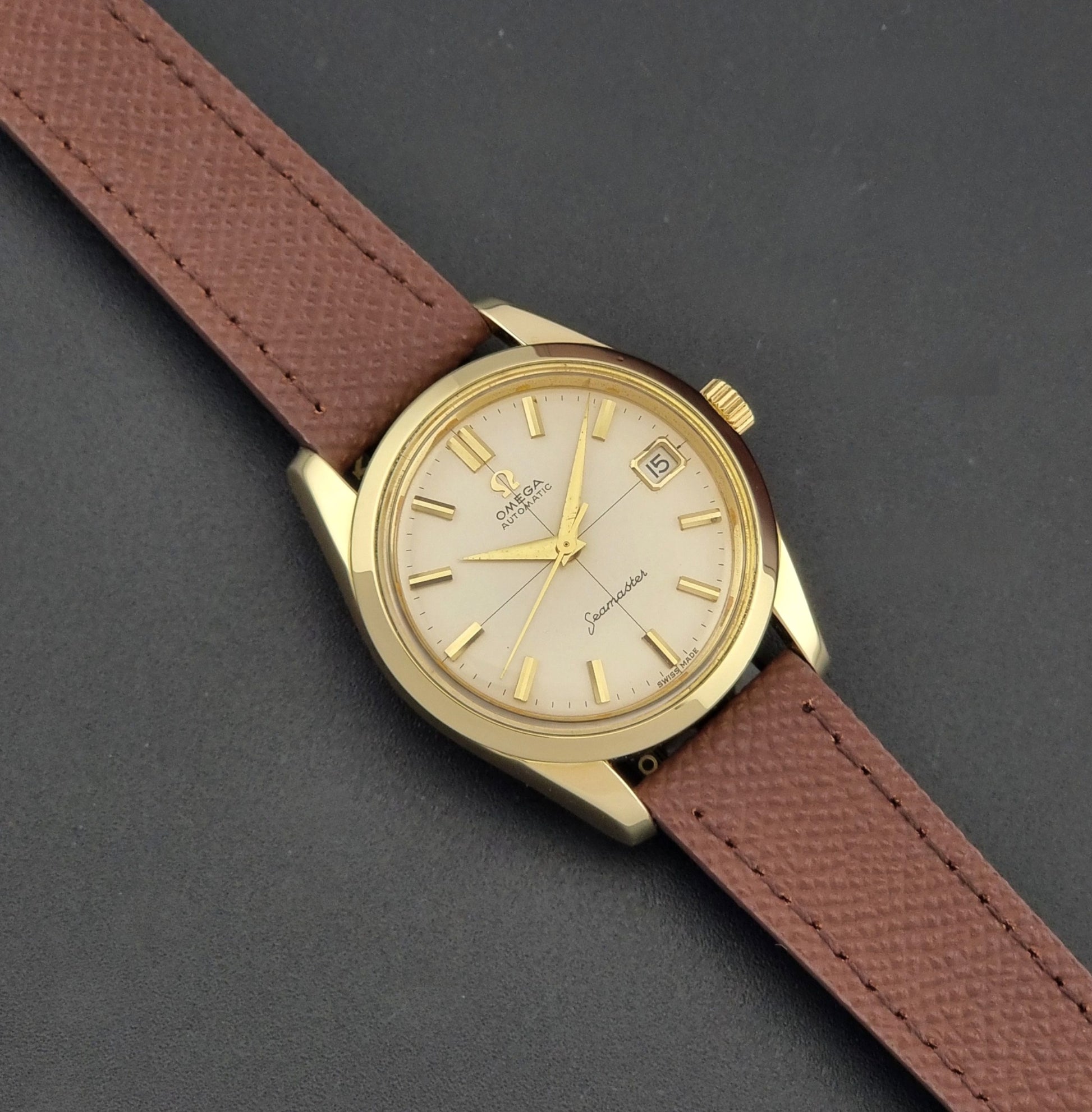 Vintage Omega Wristwatch Seamaster 14763  with a brown leather strap on a dark textured background dial