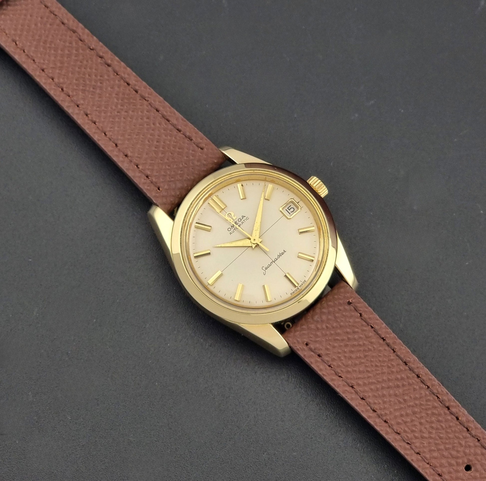 Vintage Omega Wristwatch Seamaster 14763  with a brown leather strap on a dark textured background close dial view