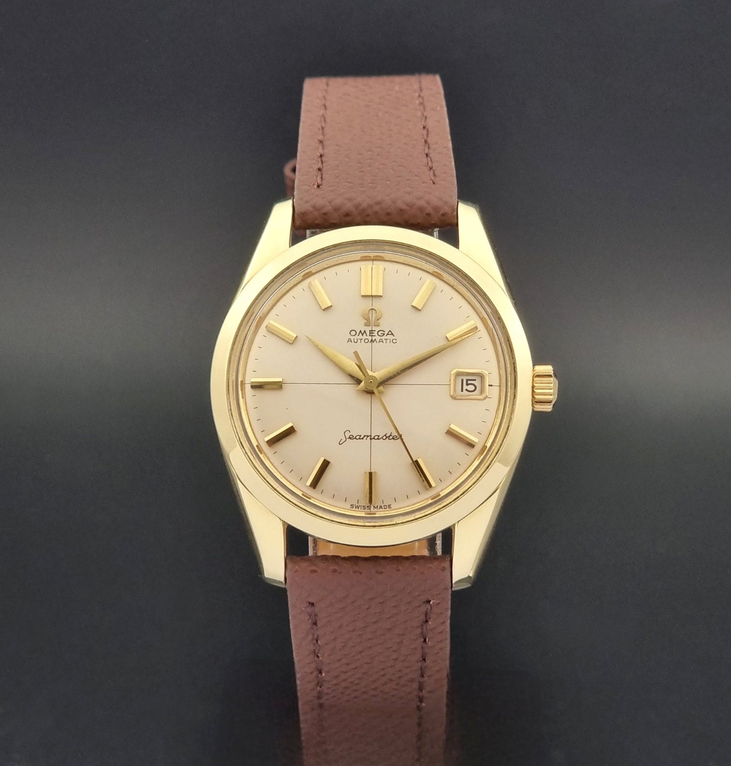 Vintage Omega Wristwatch Seamaster 14763  with a brown leather strap on a dark textured background close dial view