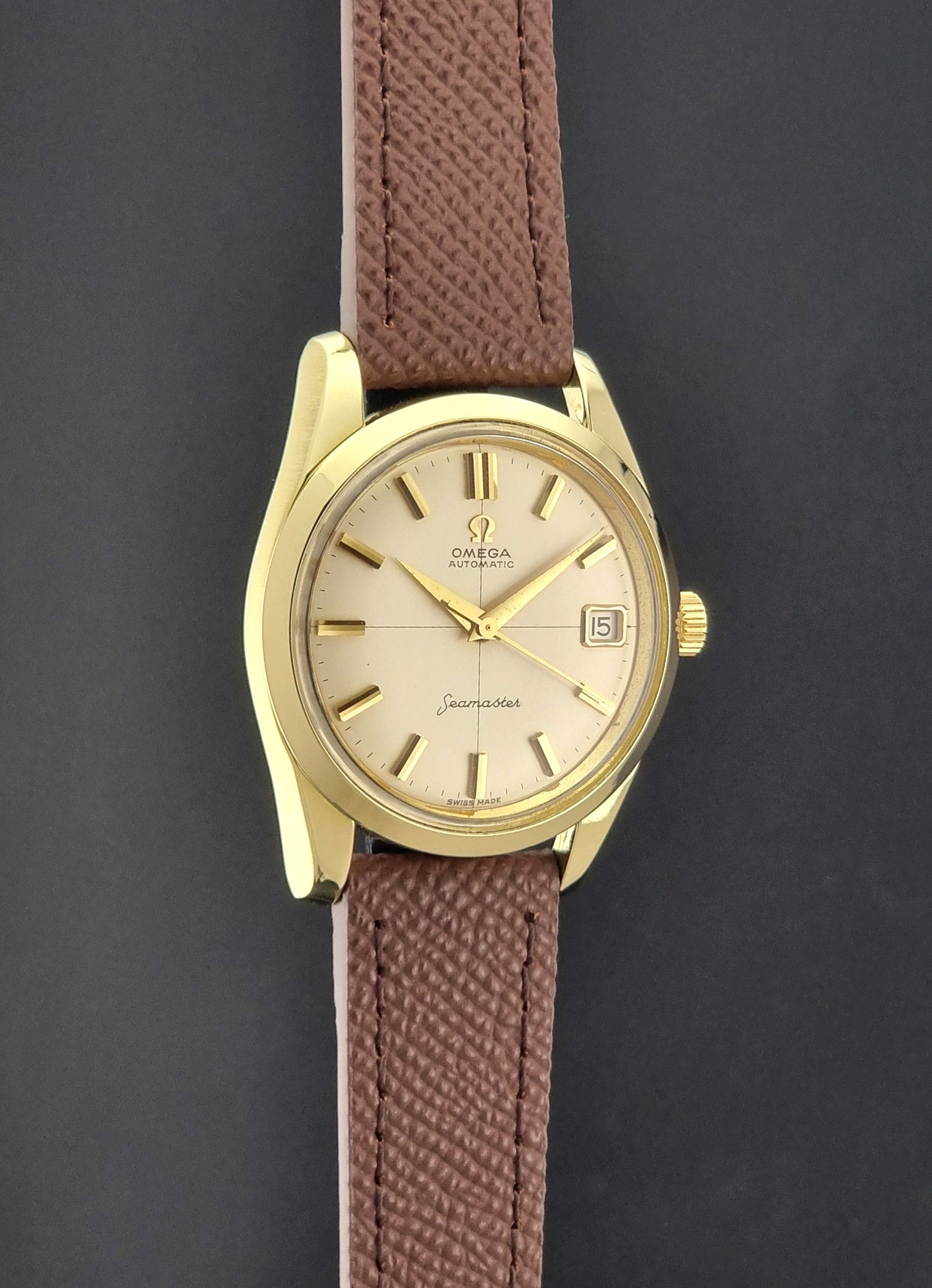 Vintage Omega Wristwatch Seamaster 14763  with a brown leather strap on a dark textured background side profie view
