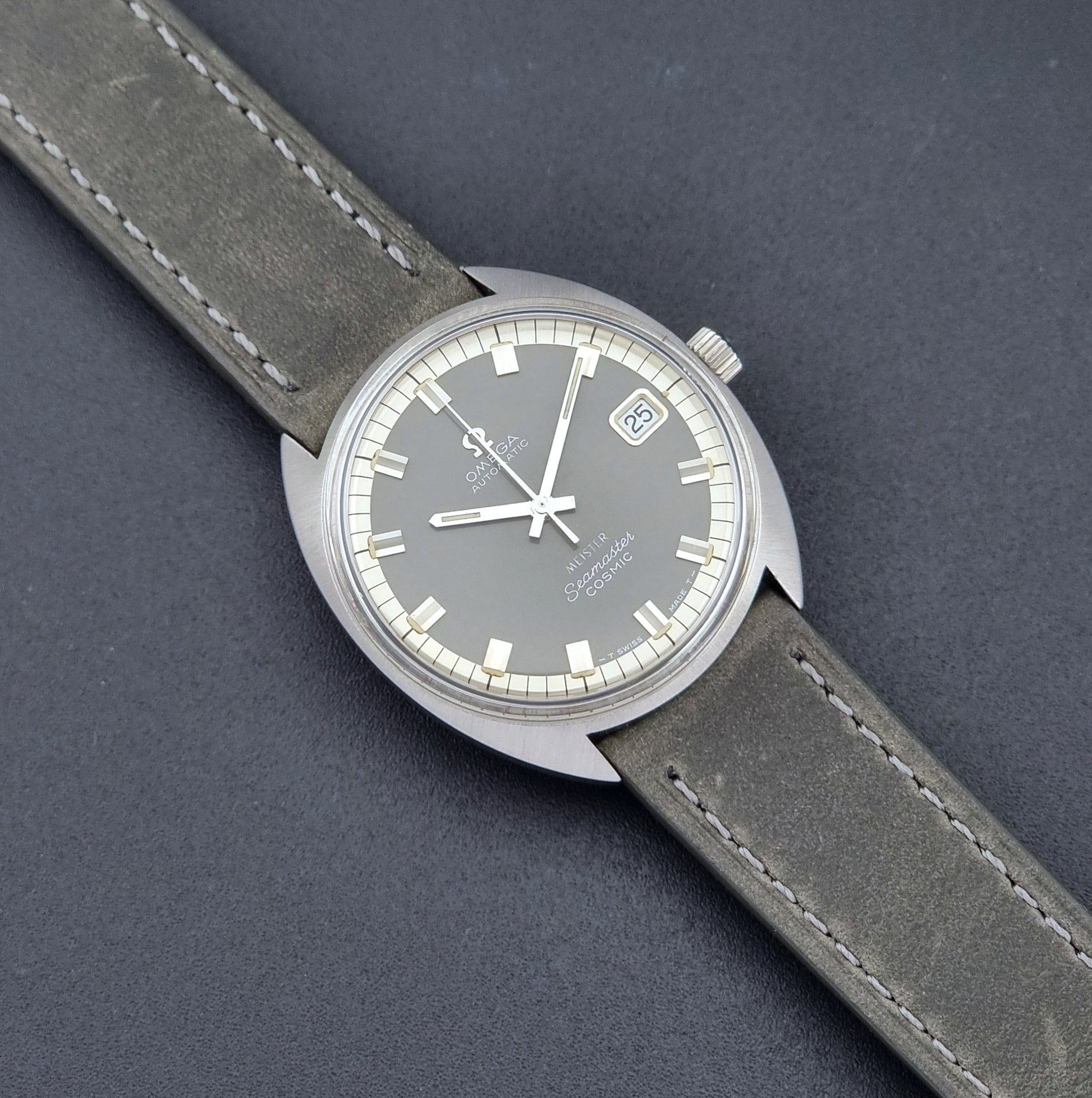 Vintage Omega Seamaster Cosmic 166.026 Wristwatch Meister Dial with leather strap on a dark gray background close up dial view