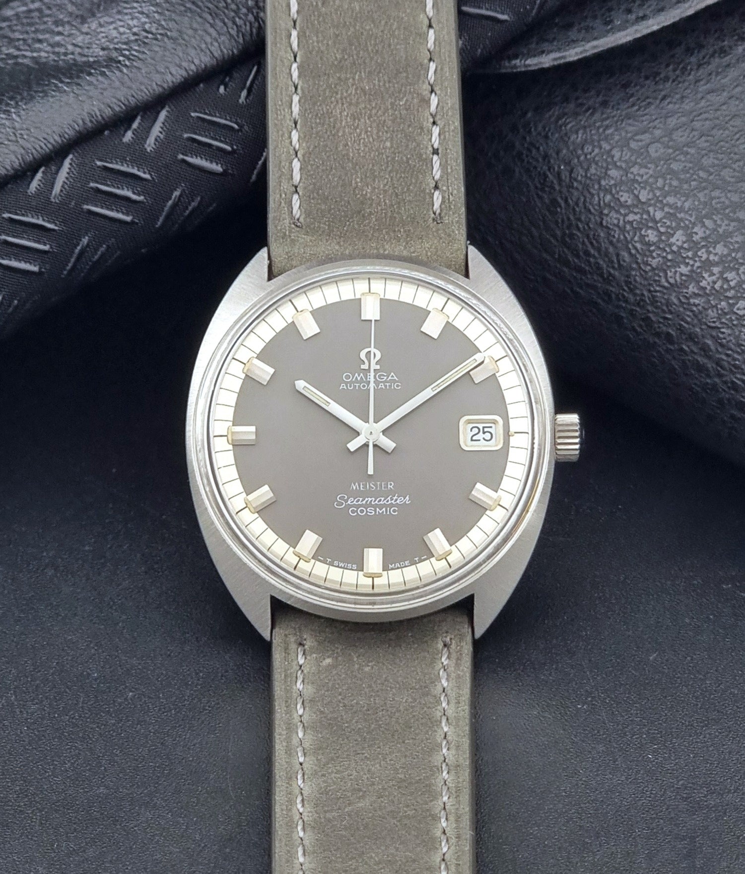 Vintage Omega Seamaster Cosmic 166.026 Wristwatch Meister Dial with leather strap on a dark gray background dial view