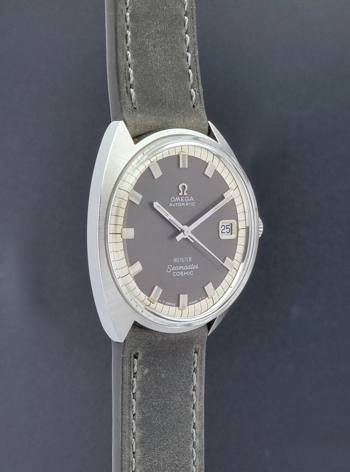Vintage Omega Seamaster Cosmic 166.026 Wristwatch Meister Dial with leather strap on a dark gray background side profile view