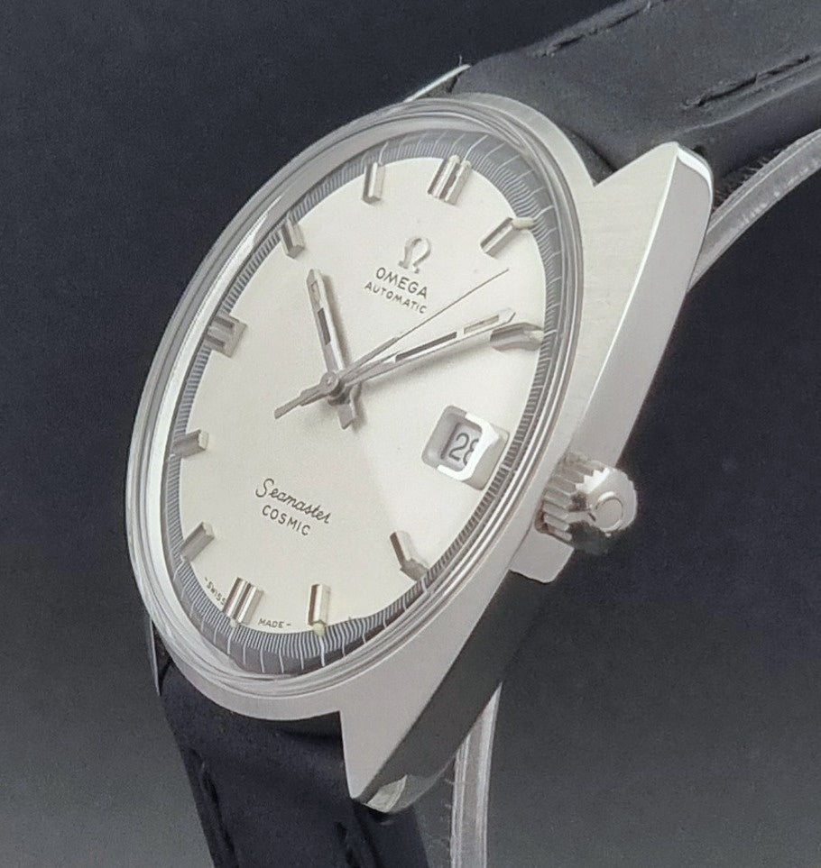 Vintage Omega Wristwatch Seamaster Cosmic 166.026 with silver dial and black leather strap on a gray background crown side profile view