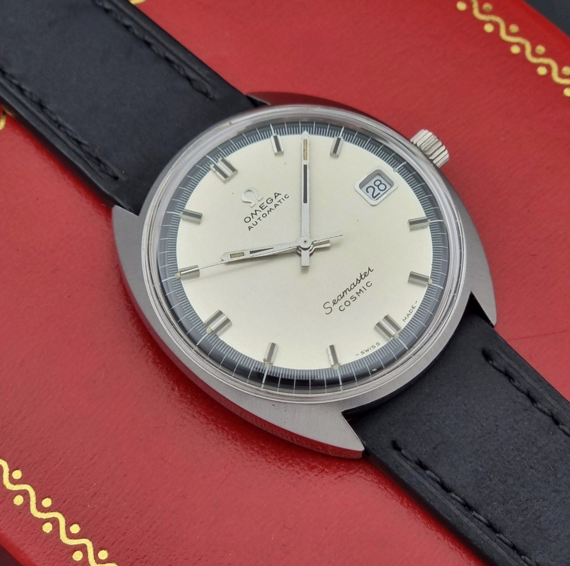 Vintage Omega Wristwatch Seamaster Cosmic 166.026 with a black leather strap on a red background