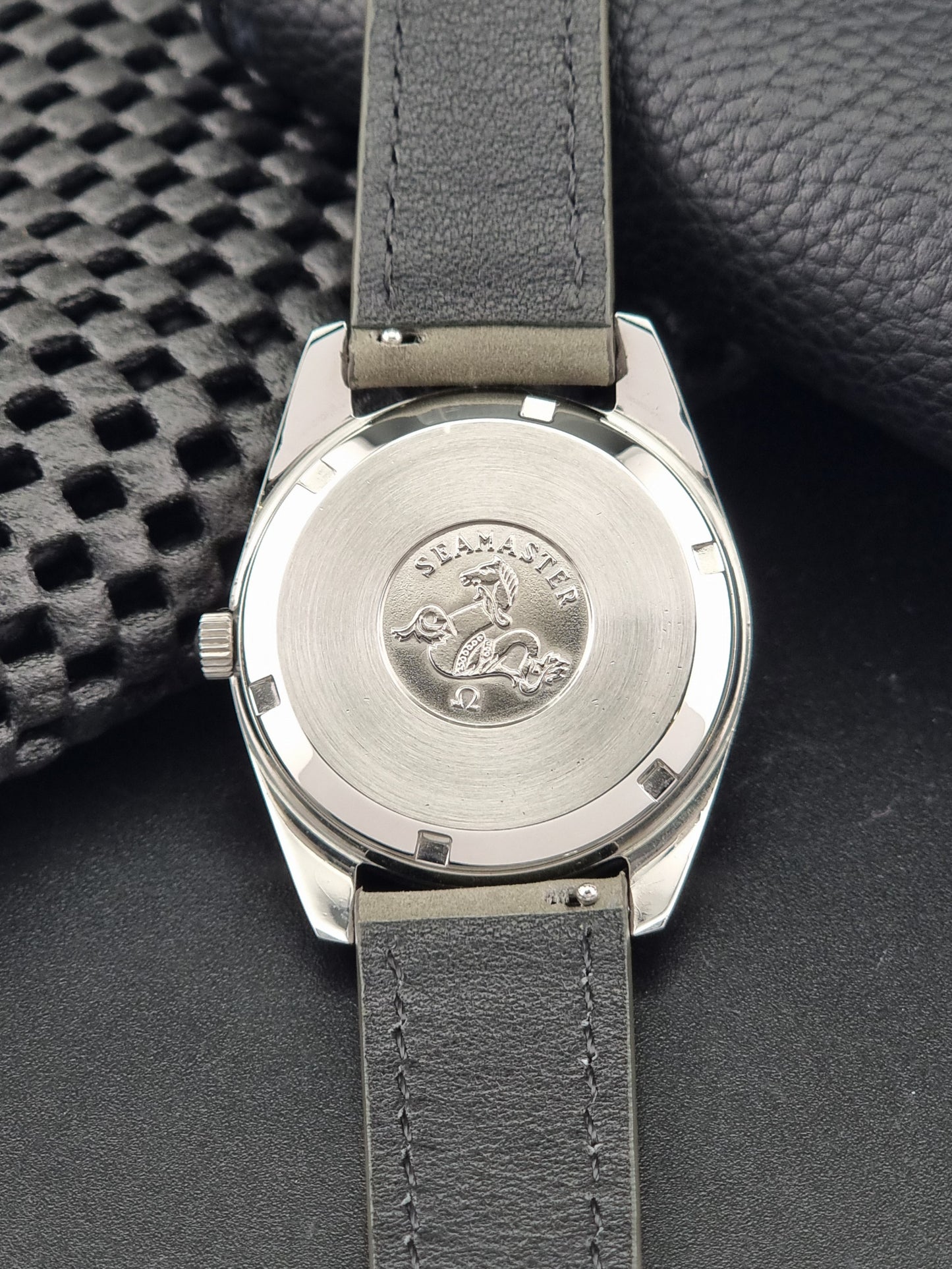 Vintage Omega Seamaster 168.0061/166.0172 watch on a grey strap and dark back ground back view