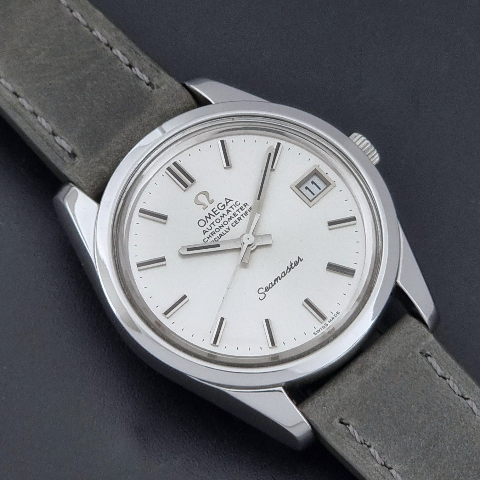 Vintage Omega Seamaster 168.0061/166.0172 watch on a grey strap and dark back ground close up dial view