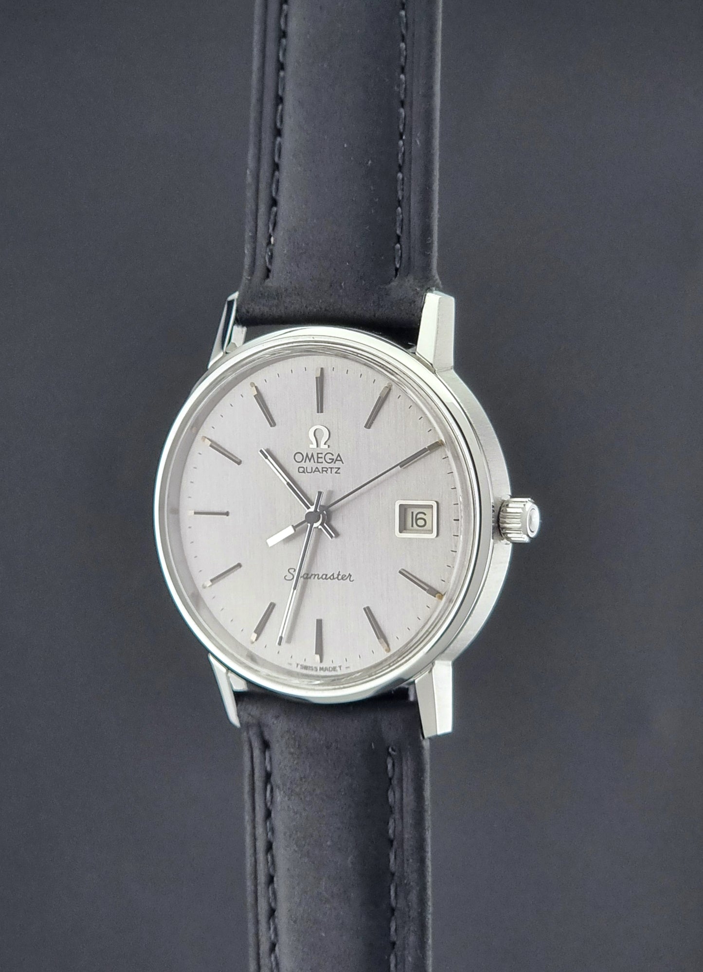 Vintage Omega Quartz Wristwatch Seamaster 196.0079 watch with a black strap on a gray background crown profile view
