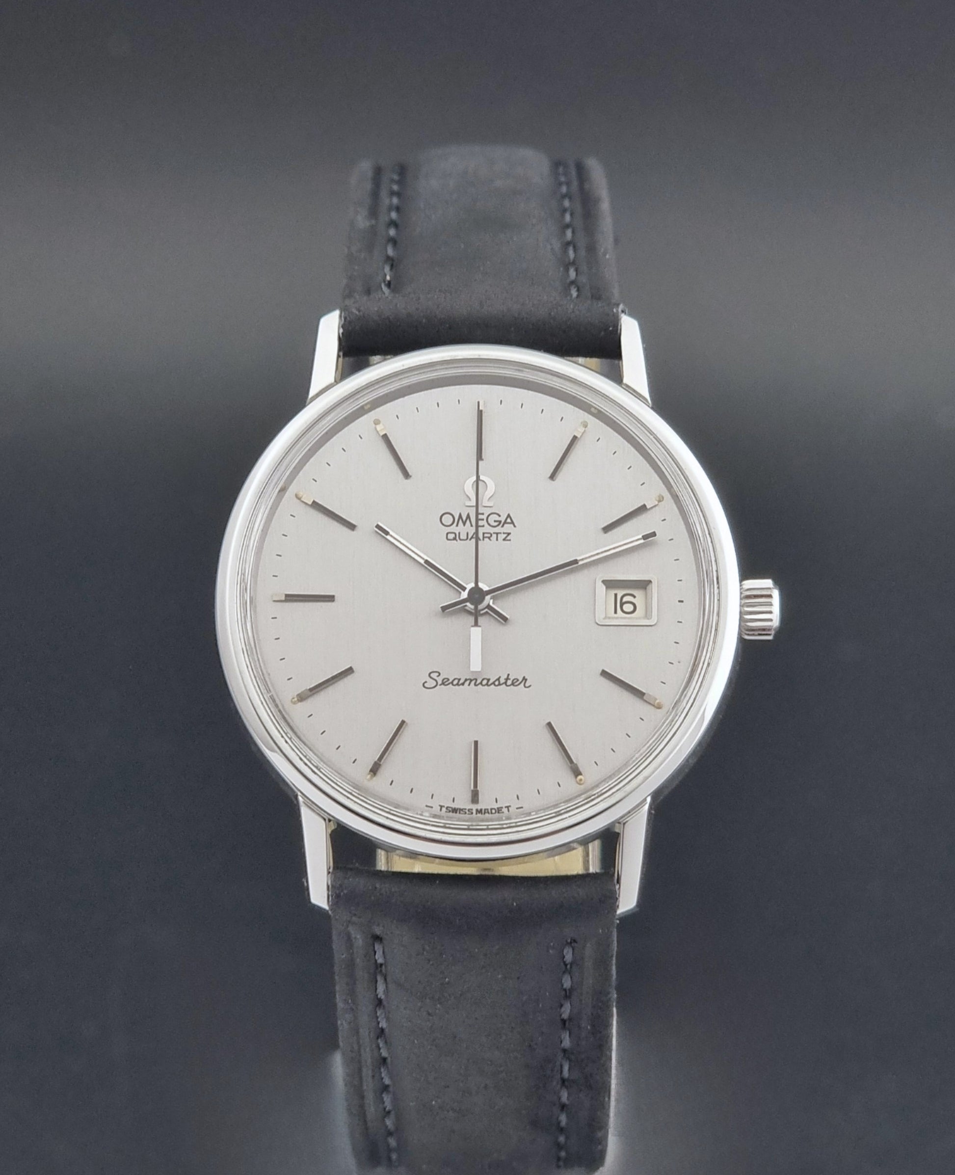 Vintage Omega Quartz Wristwatch Seamaster 196.0079 watch with a black strap on a gray background close dial view