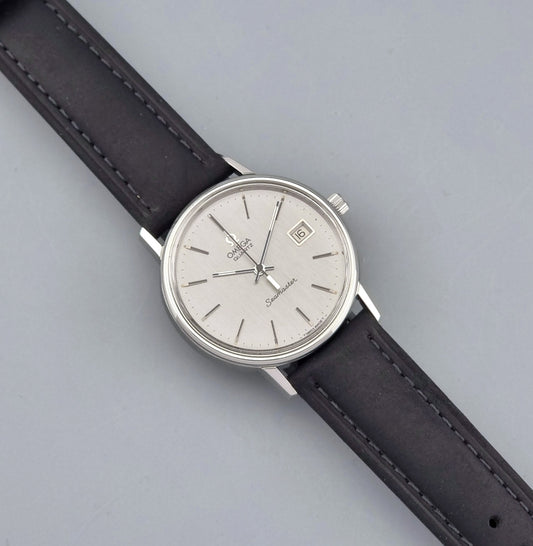 Vintage Omega Quartz Wristwatch Seamaster 196.0079 watch with a black strap on a gray background dial