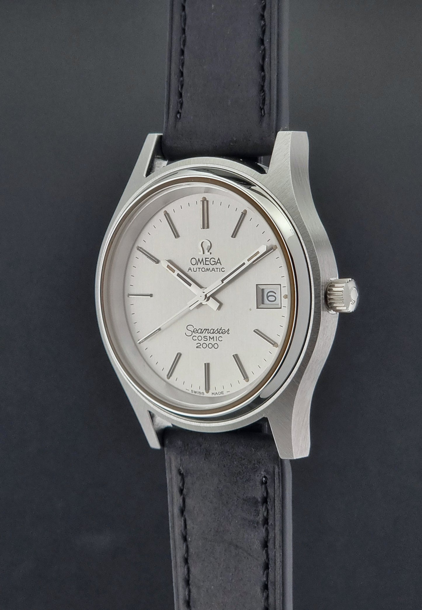 Vintage Omega Wristwatch Seamaster Cosmic 2000 Jumbo 166.128 watch with black leather strap on a dark surface crown profile view