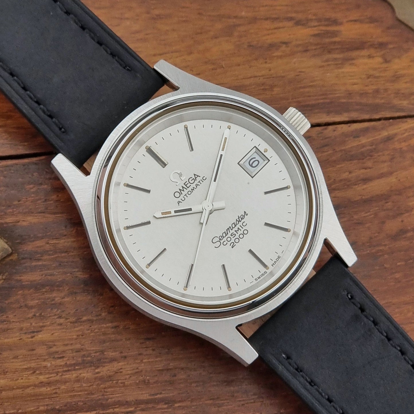 Vintage Omega Wristwatch Seamaster Cosmic 2000 Jumbo 166.128 watch with black leather strap on a wooden surface dial view