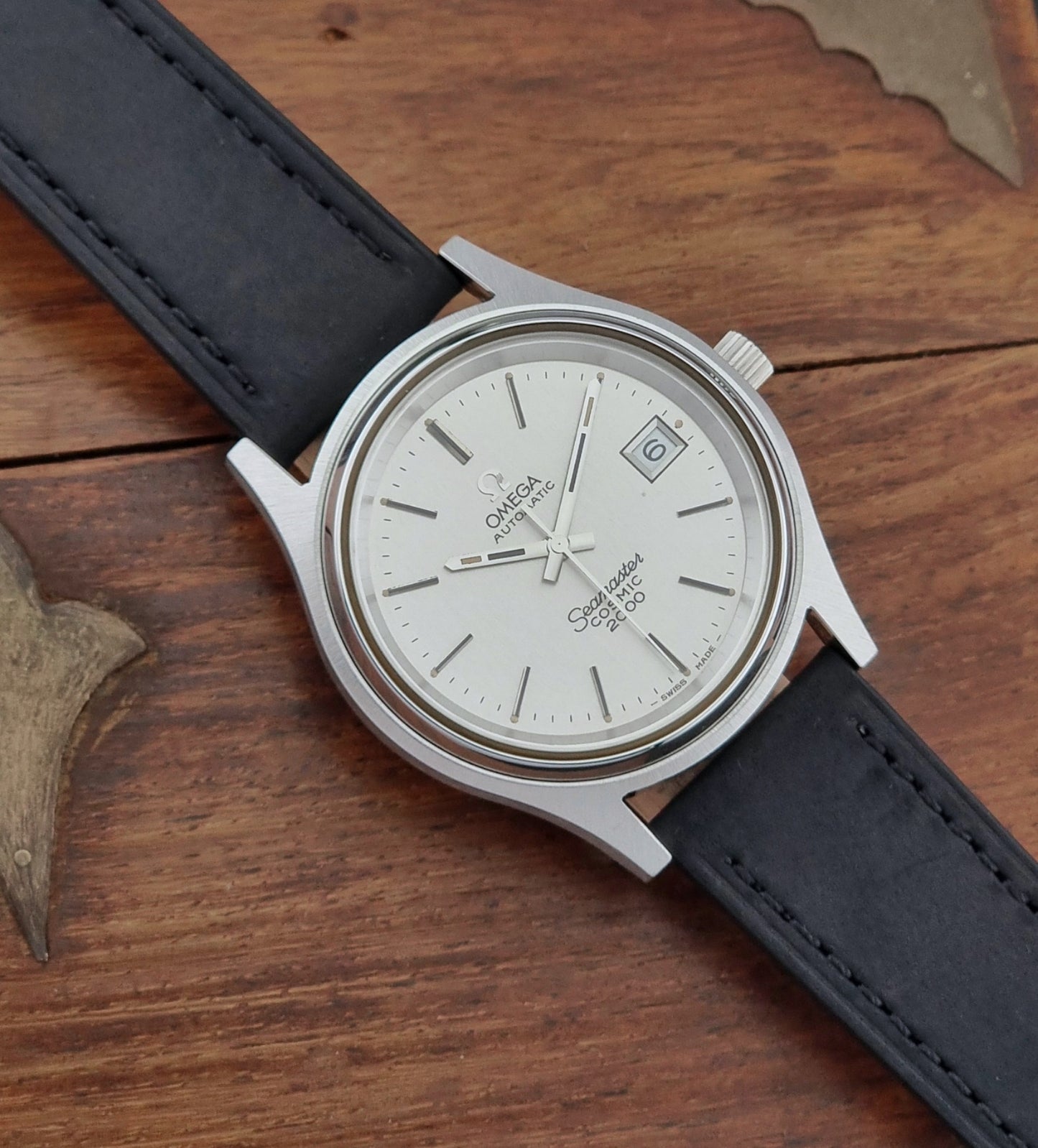 Vintage Omega Wristwatch Seamaster Cosmic 2000 Jumbo 166.128 watch with black leather strap on a wooden surface