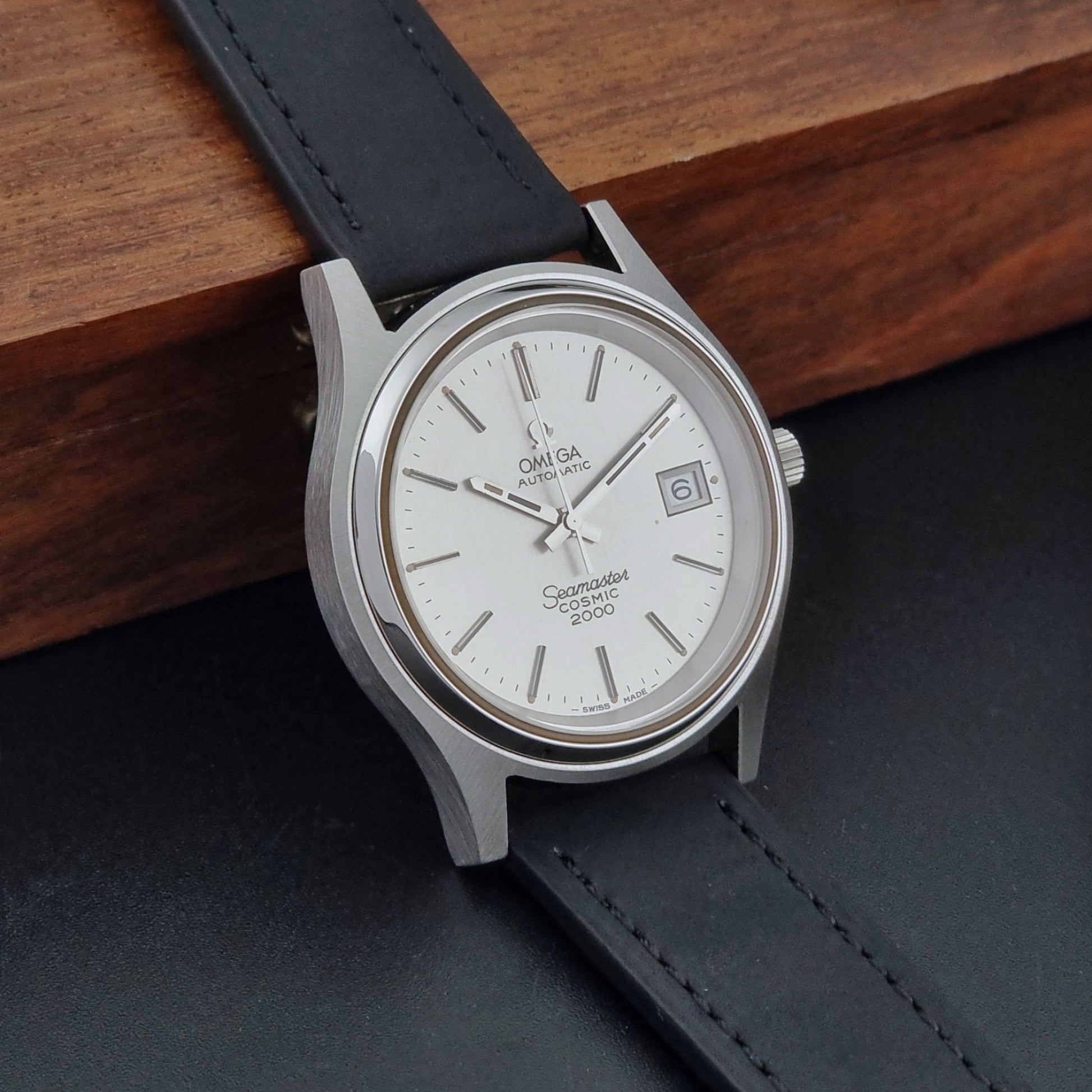 Vintage Omega Wristwatch Seamaster Cosmic 2000 Jumbo 166.128 watch with black leather strap on a wooden surface side view