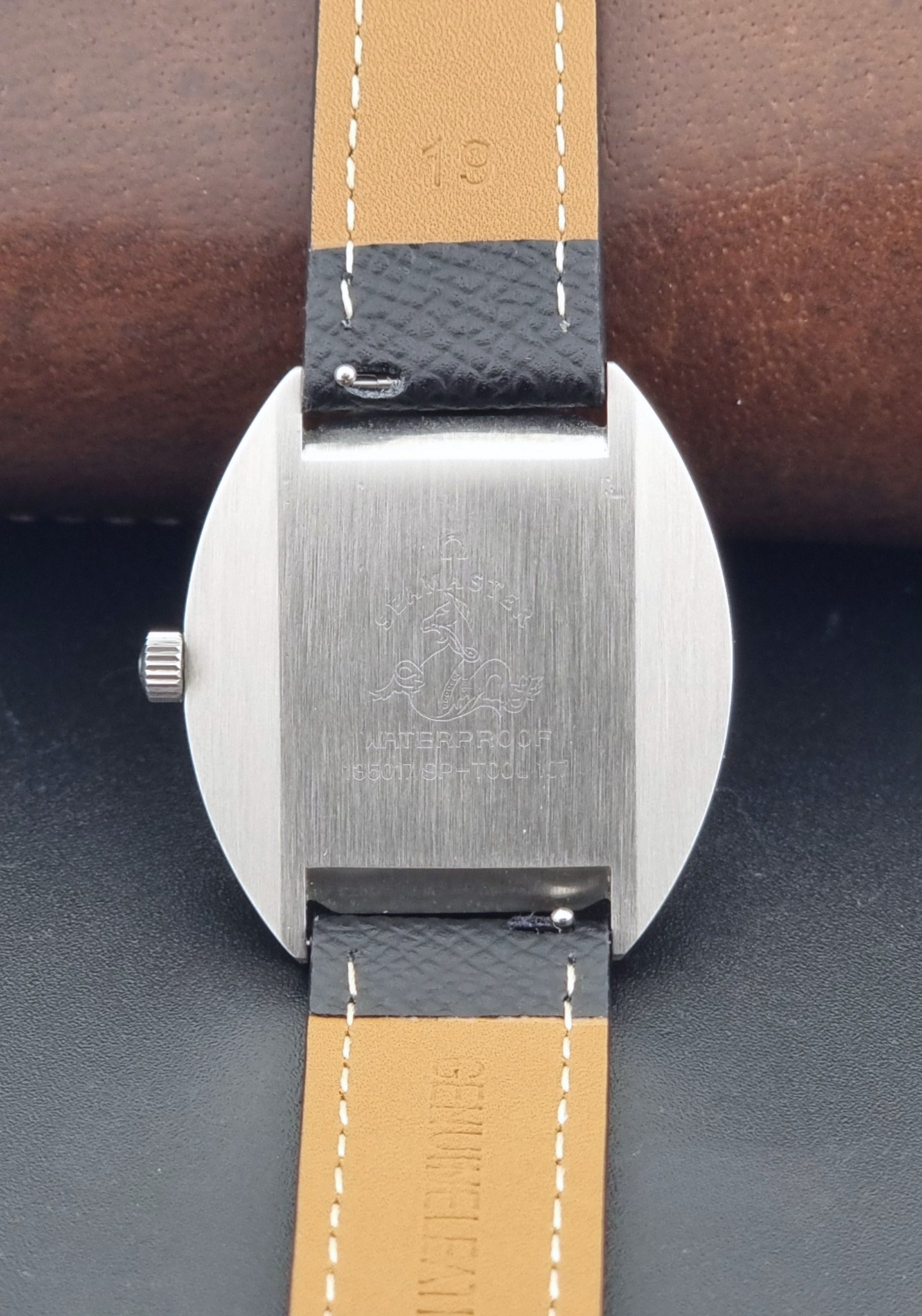 Vintage Omega Seamaster Cosmic 135.017 watch with a white face on a dark surface case back view