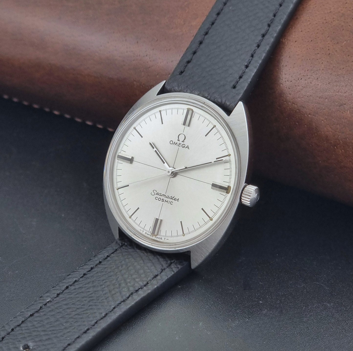Vintage Omega Seamaster Cosmic 135.017 watch with a white face on a dark surface crown view