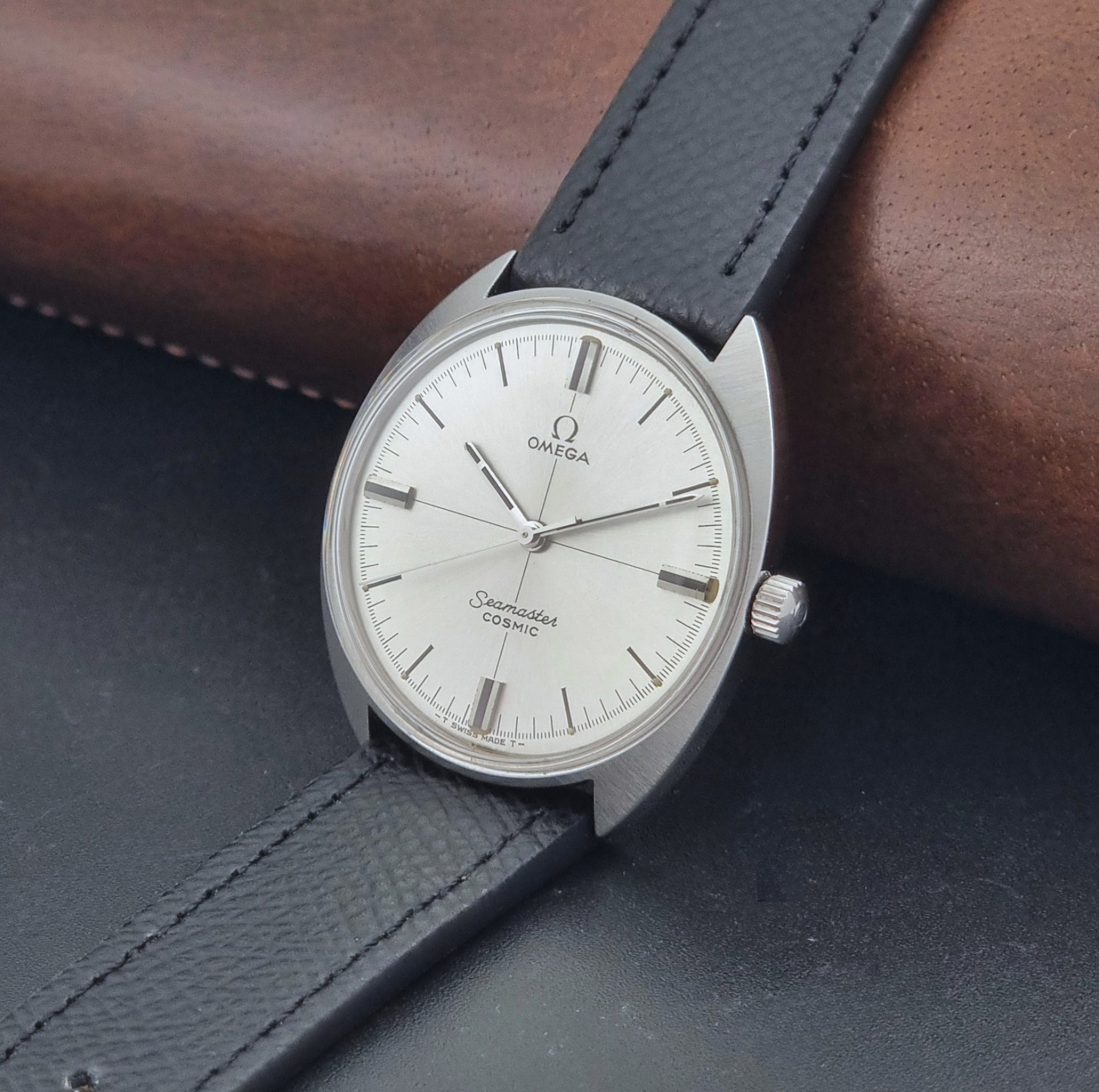 Vintage Omega Seamaster Cosmic 135.017 watch with a white face on a dark surface crown view