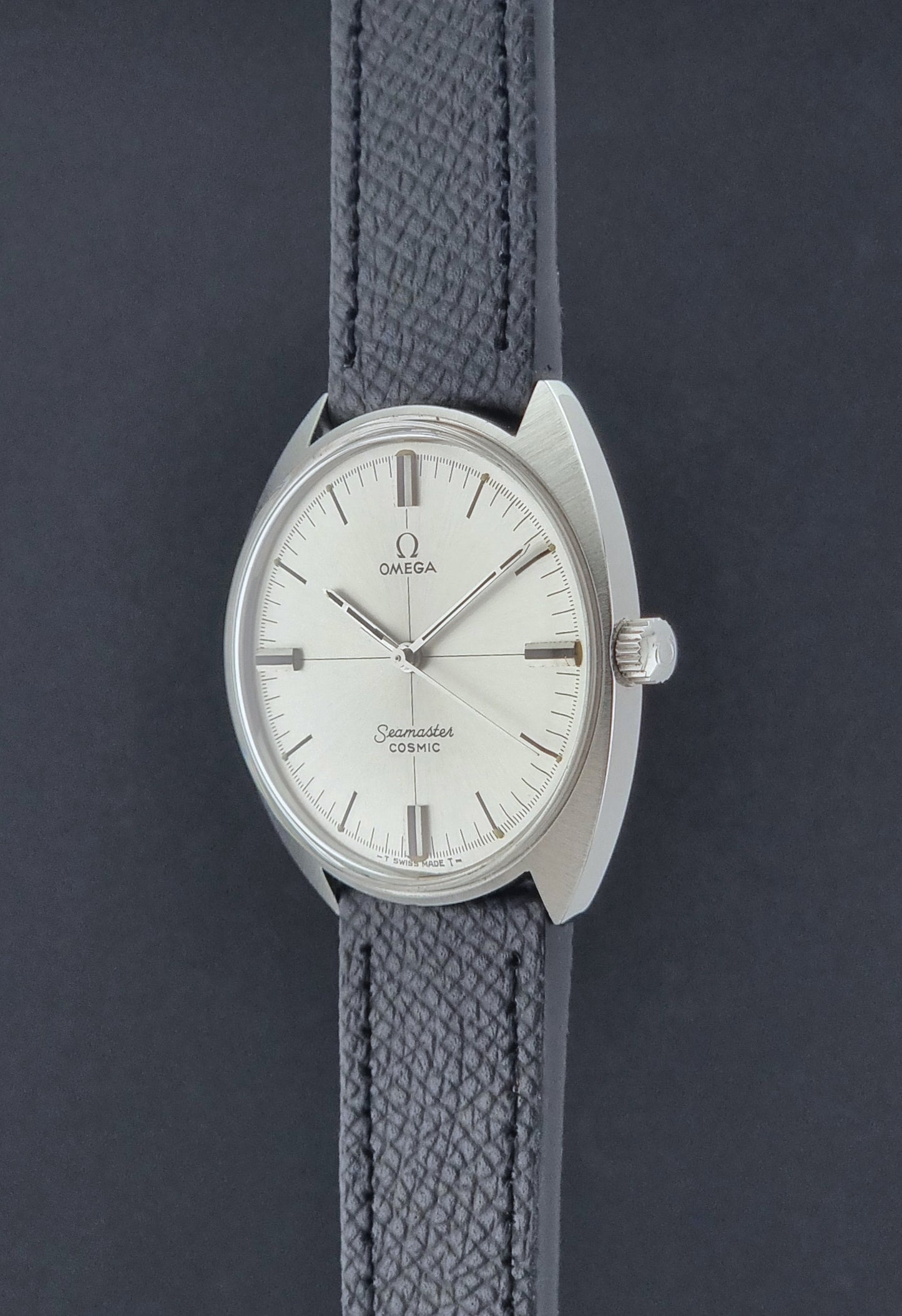 Vintage Omega Seamaster Cosmic 135.017 watch with a white face on a dark surface crown profile view