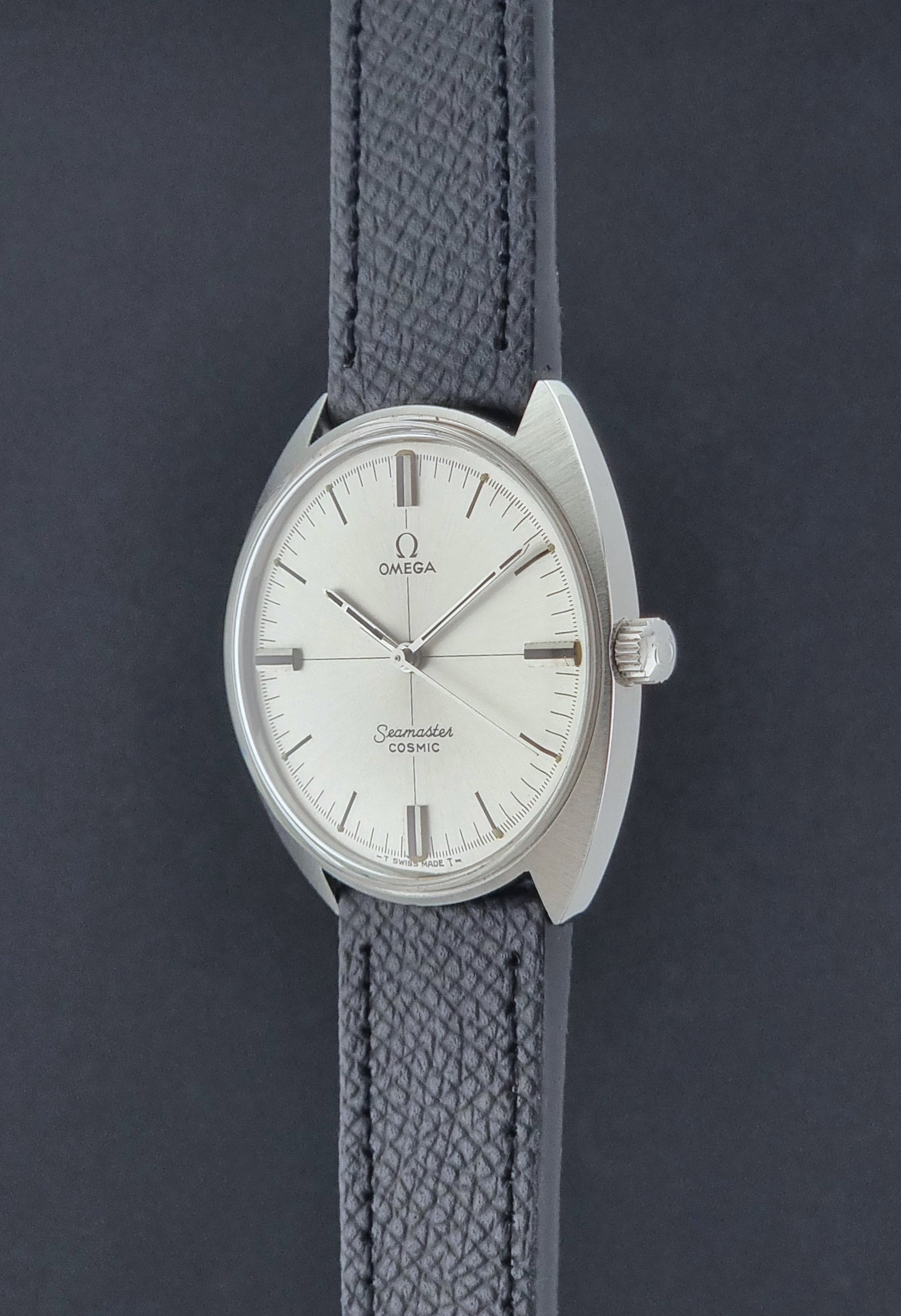 Vintage Omega Seamaster Cosmic 135.017 watch with a white face on a dark surface crown profile view