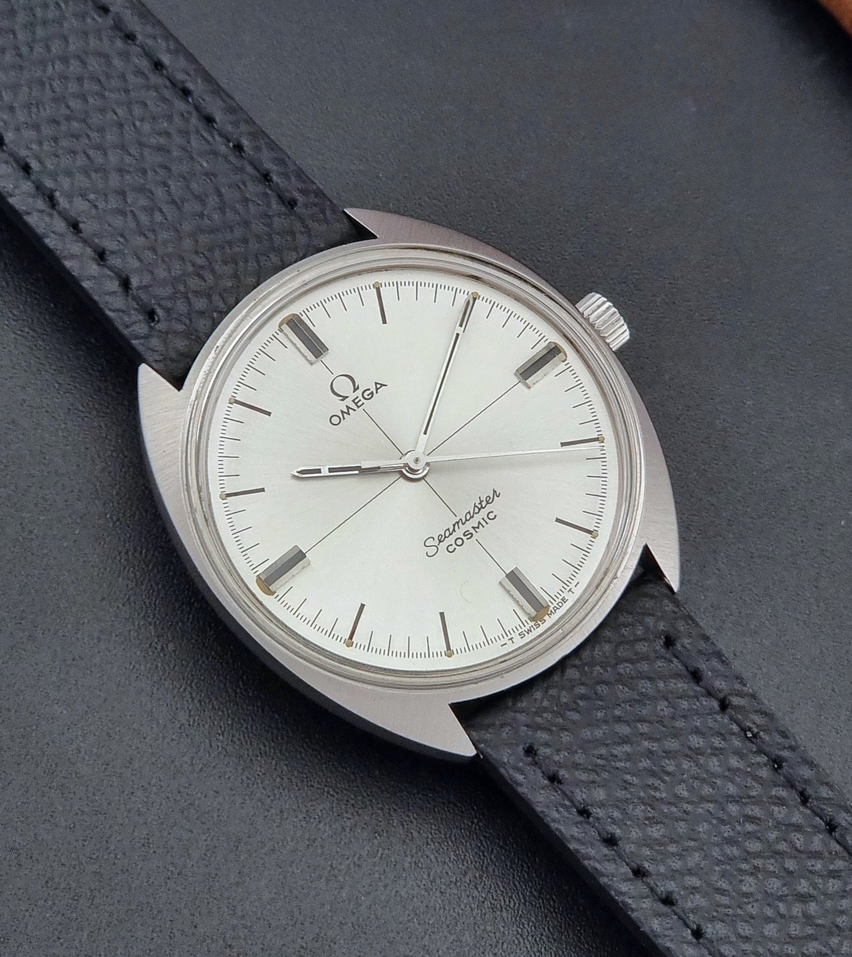 Vintage Omega Seamaster Cosmic 135.017 watch with a white face on a dark surface close up dial view