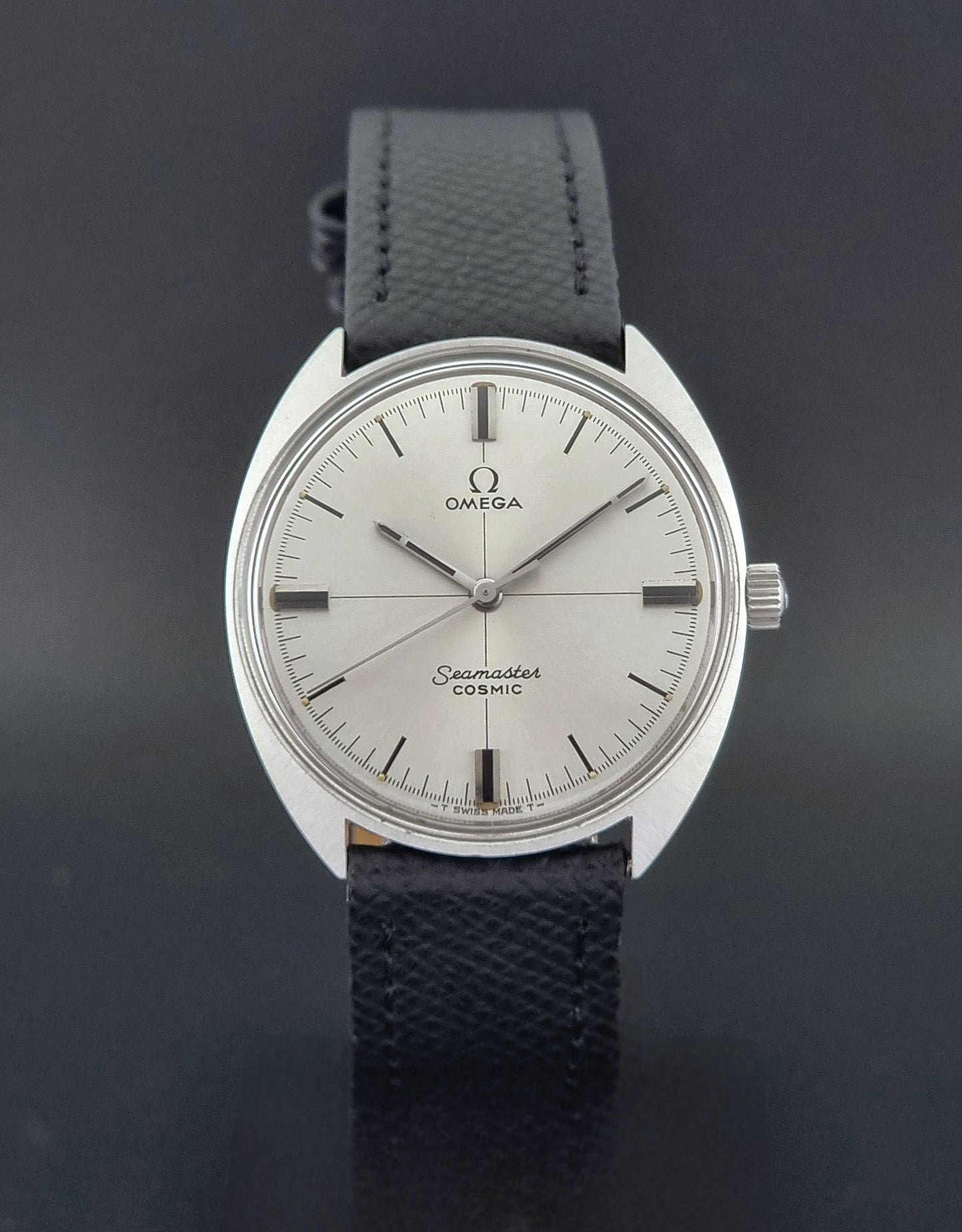 Vintage Omega Seamaster Cosmic 135.017 watch with a white face on a dark surface close dial view