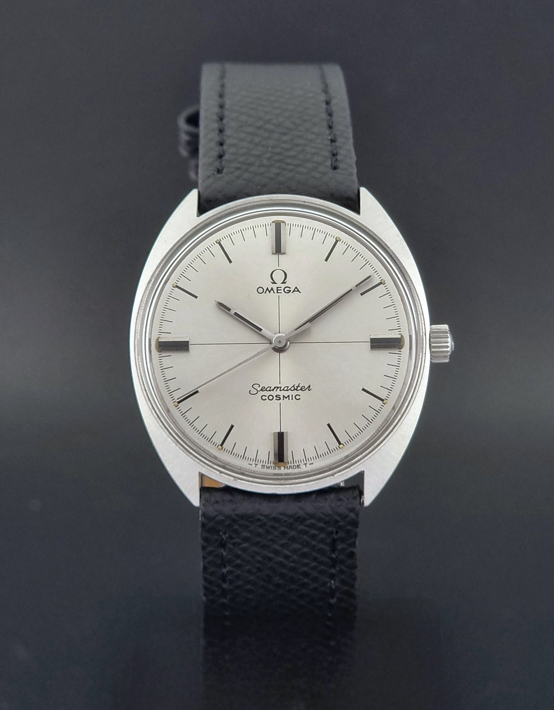 Vintage Omega Seamaster Cosmic 135.017 watch with a white face on a dark surface close dial view