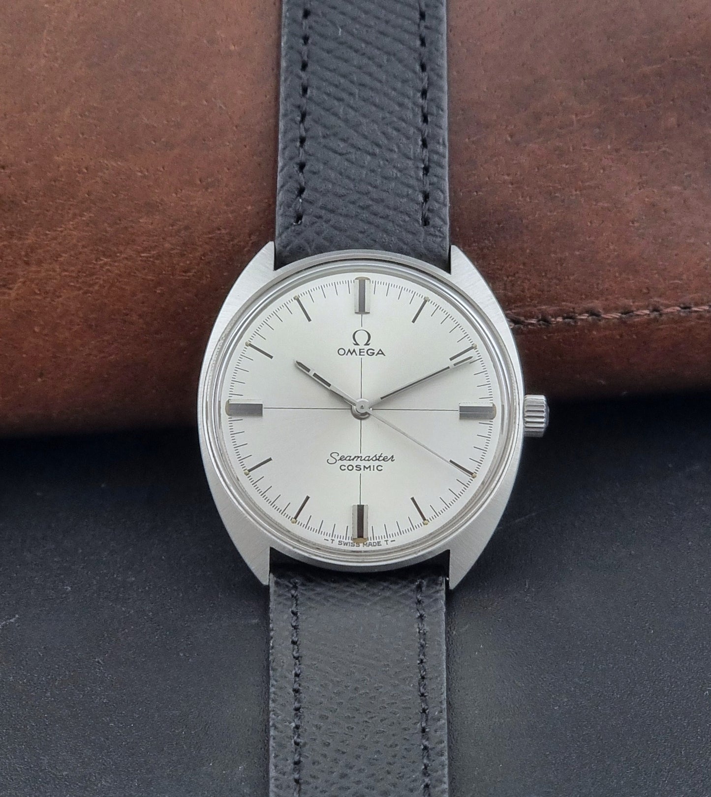 Vintage Omega Seamaster Cosmic 135.017 watch with a white face on a dark surface dial view