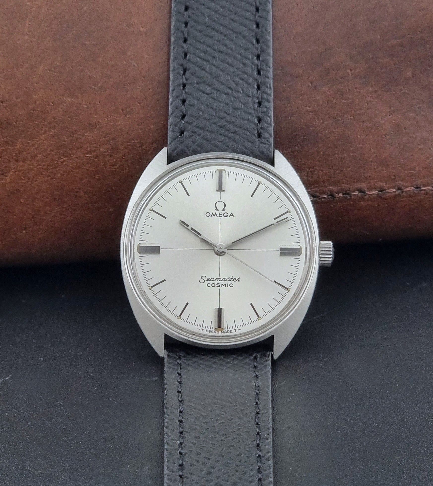 Vintage Omega Seamaster Cosmic 135.017 watch with a white face on a dark surface dial view
