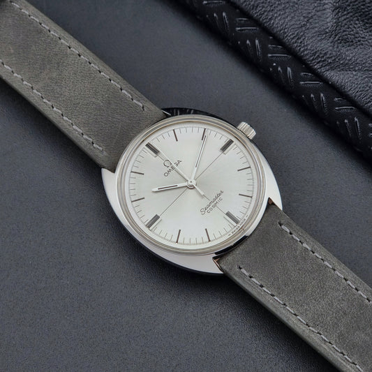 Omega Watch Seamaster Cosmic Crosshair Dial with gray strap on a dark surface