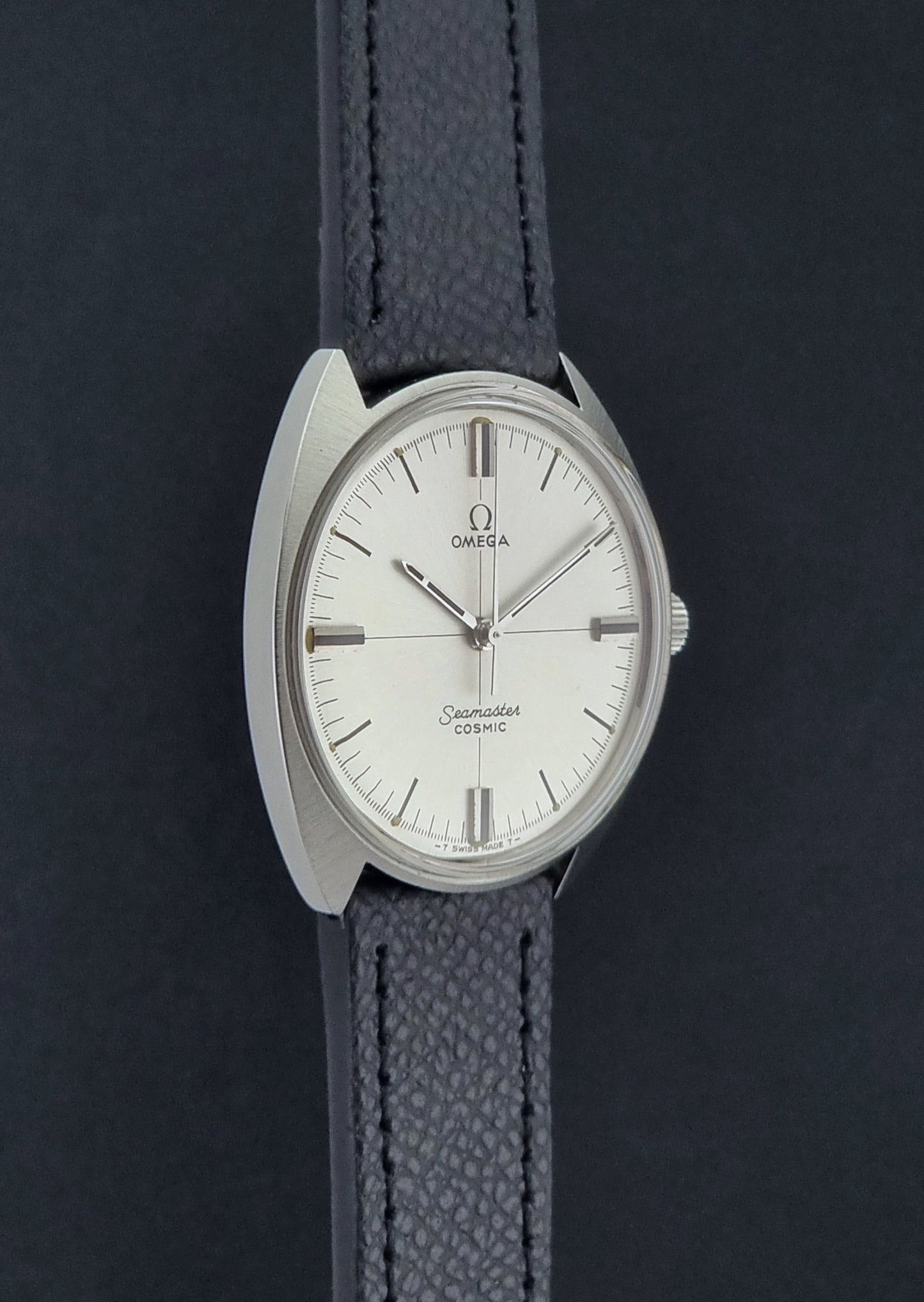Vintage Omega Seamaster Cosmic 135.017 watch with a white face on a dark surface side profile view