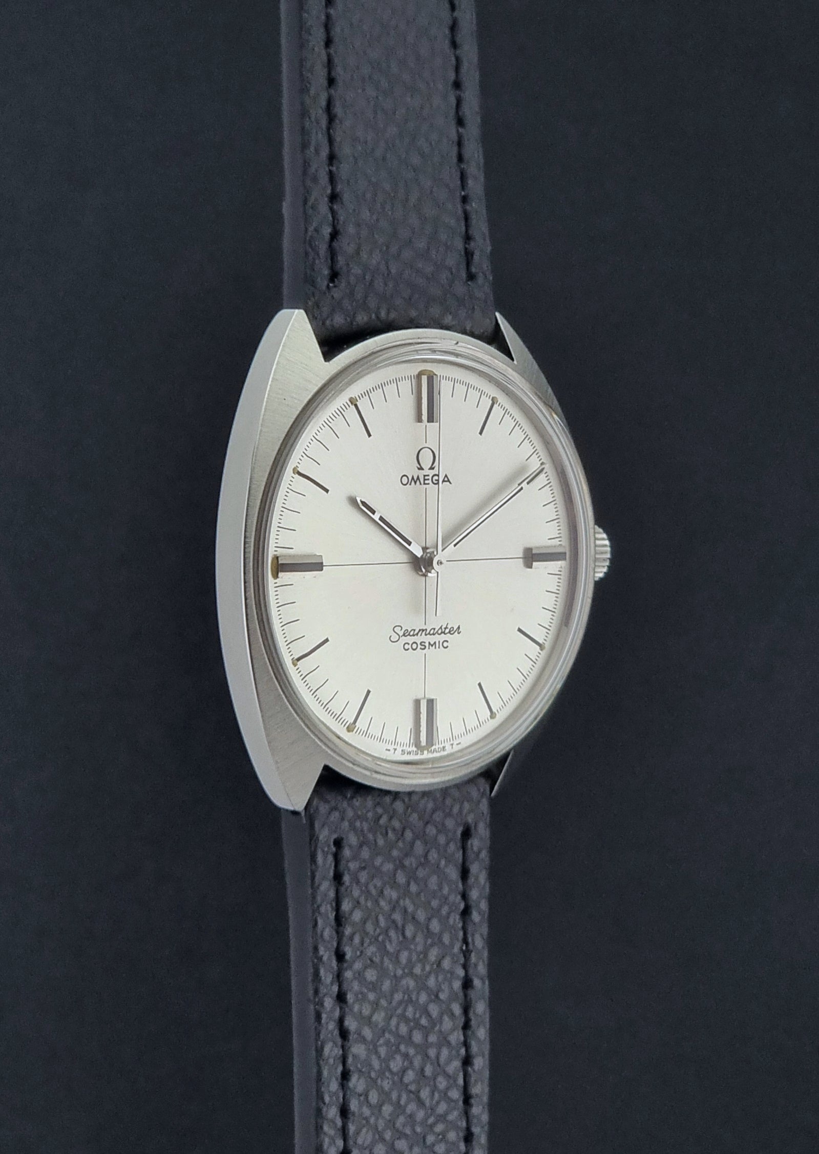 Vintage Omega Seamaster Cosmic 135.017 watch with a white face on a dark surface side profile view