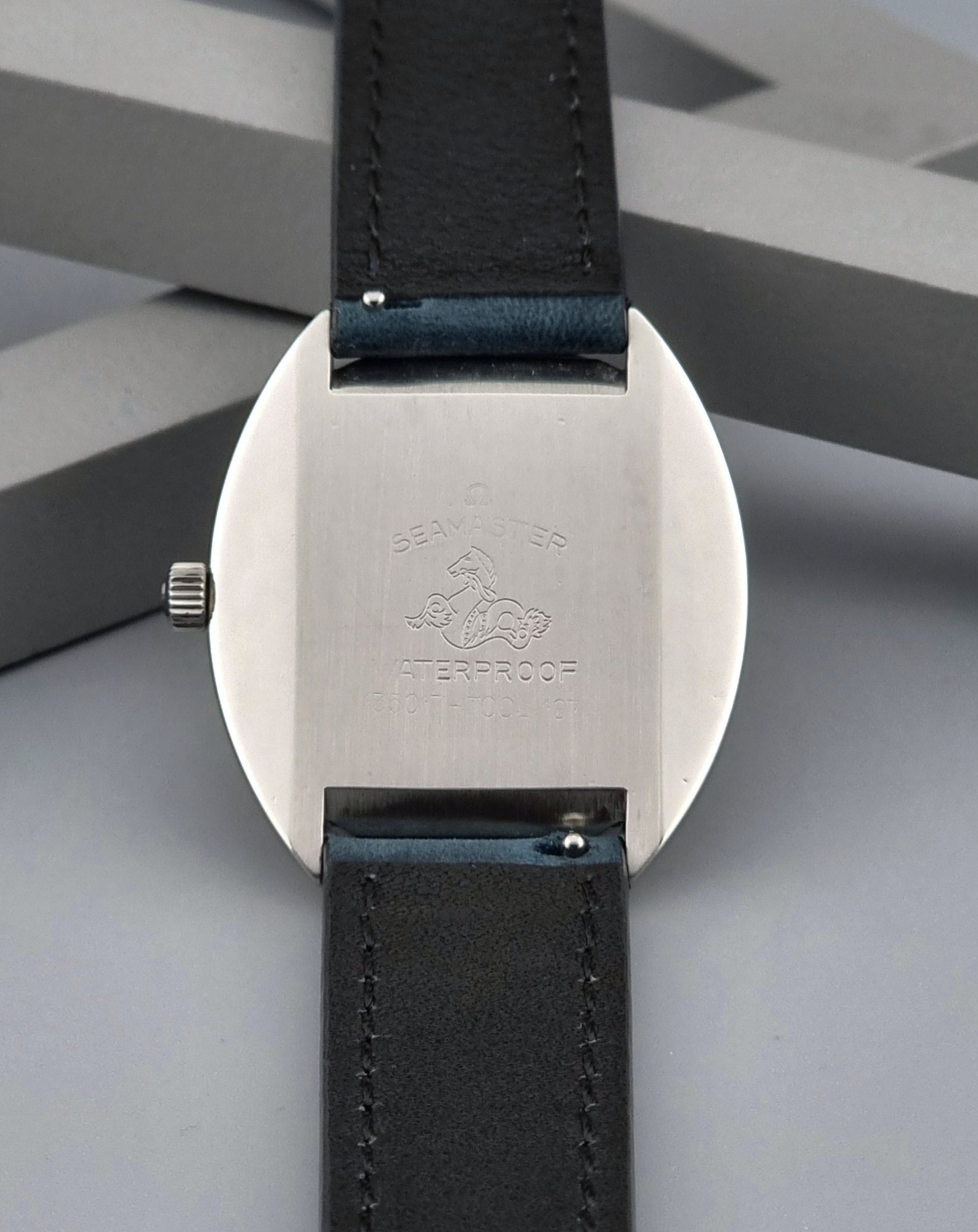 Vintage Omega Wristwatch Seamaster Cosmic 135.017 with blue leather strap on a gray background case back view